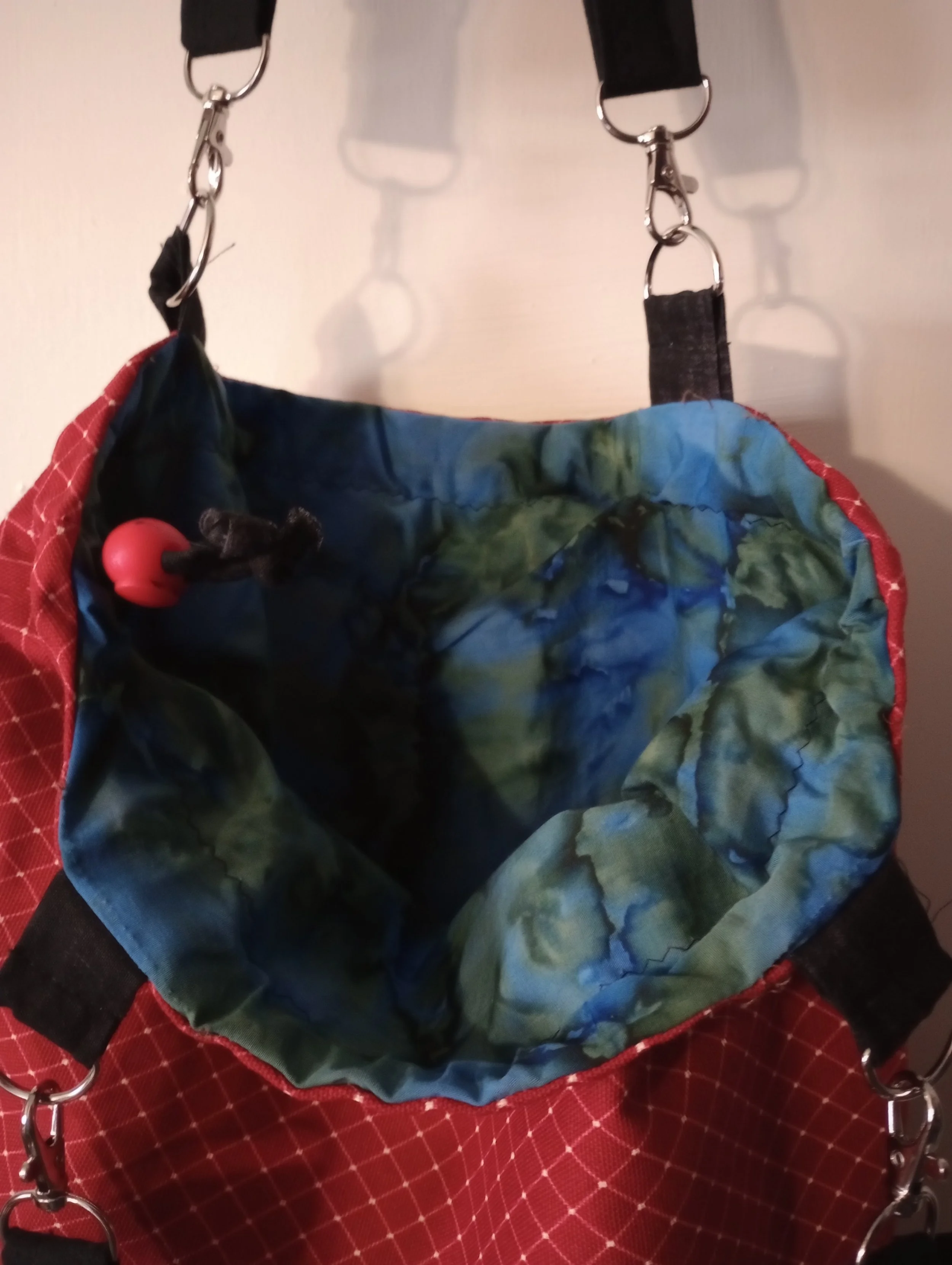 Abstract blue and green liner inside red duck cloth bag.  Red toggle.