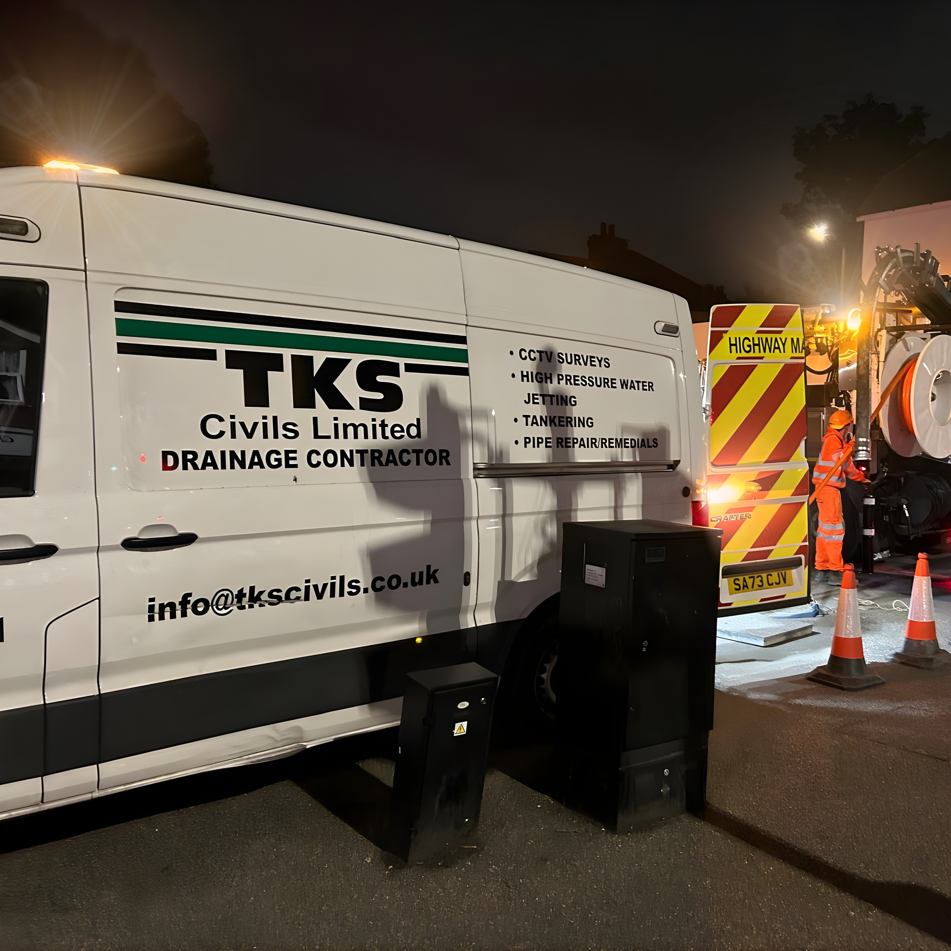 A white van with TKS Civils Limited branding, parked near a construction site at night, with a worker in orange safety gear and traffic cones nearby. The van displays services like CCTV surveys, high-pressure water jetting, tankering, and pipe repairs.