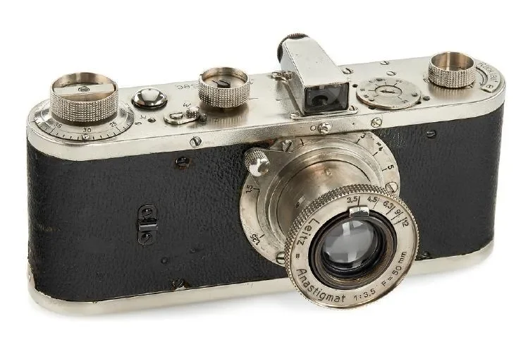 Vintage 35mm camera with black leather body and silver metal parts, including a lens marked 'Leitz Hastingmat', dials, and a viewfinder.