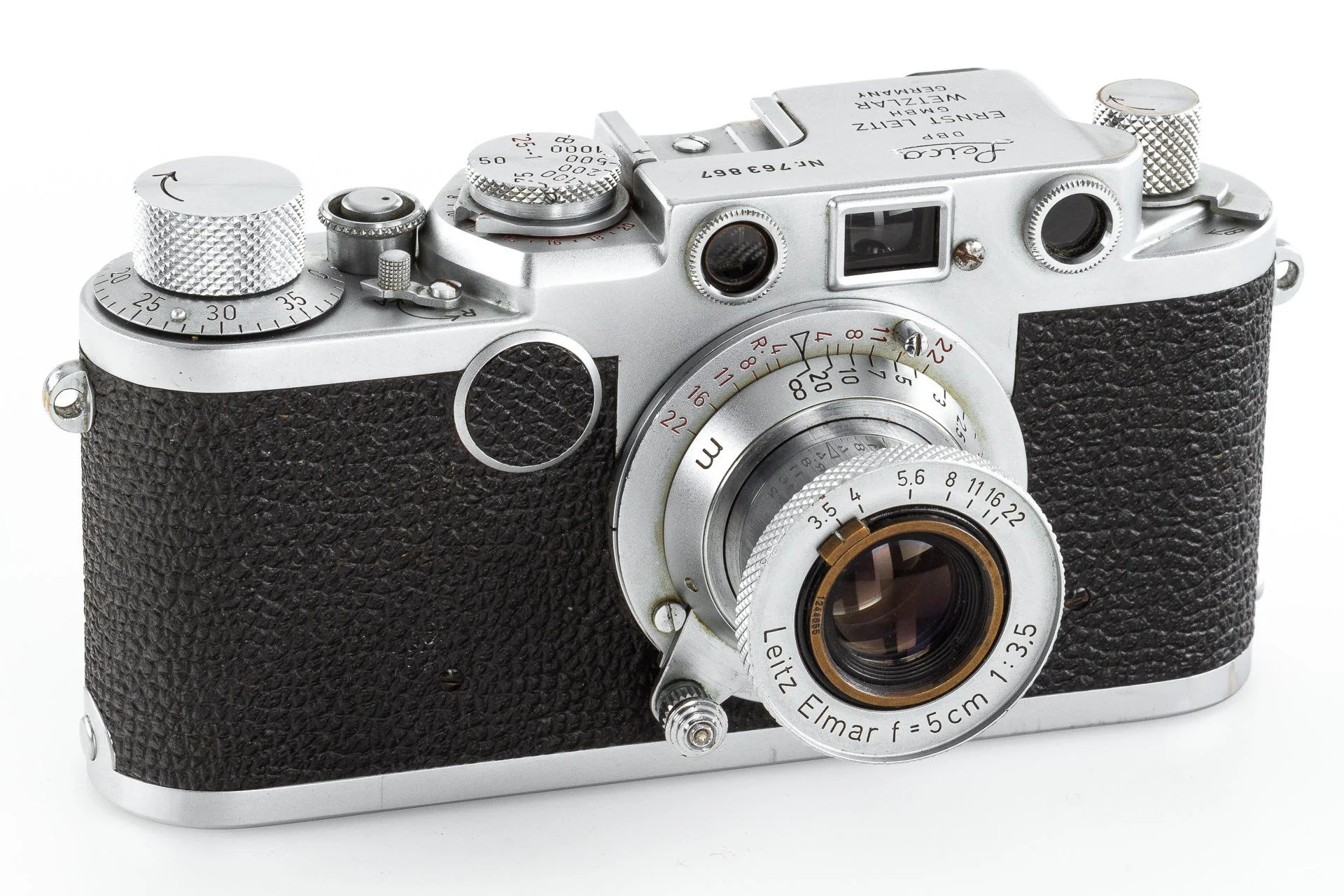 A vintage Leica camera with a silver metal body, black textured grip, and various dials and buttons, featuring a lens marked "Leitz Elmar" with a 5cm focal length and f/3.5 aperture.