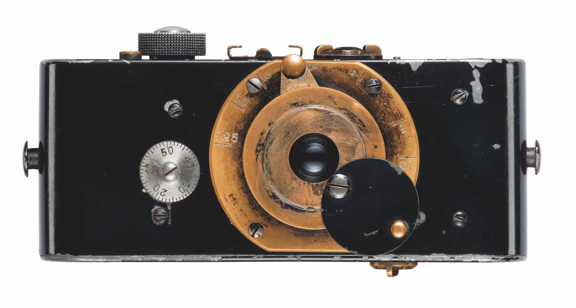 An antique camera with a black body, a brass lens, and vintage knobs and dials on a white background.
