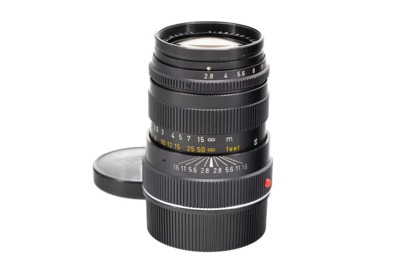 A camera lens with a lens cap placed nearby.