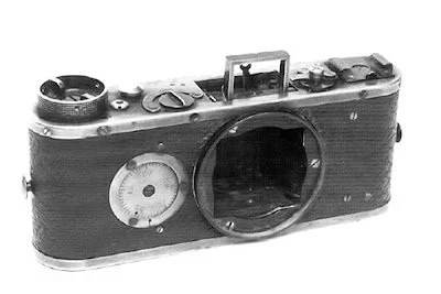 Black and white photo of an old vintage camera body with a lens mount, without a lens attached.