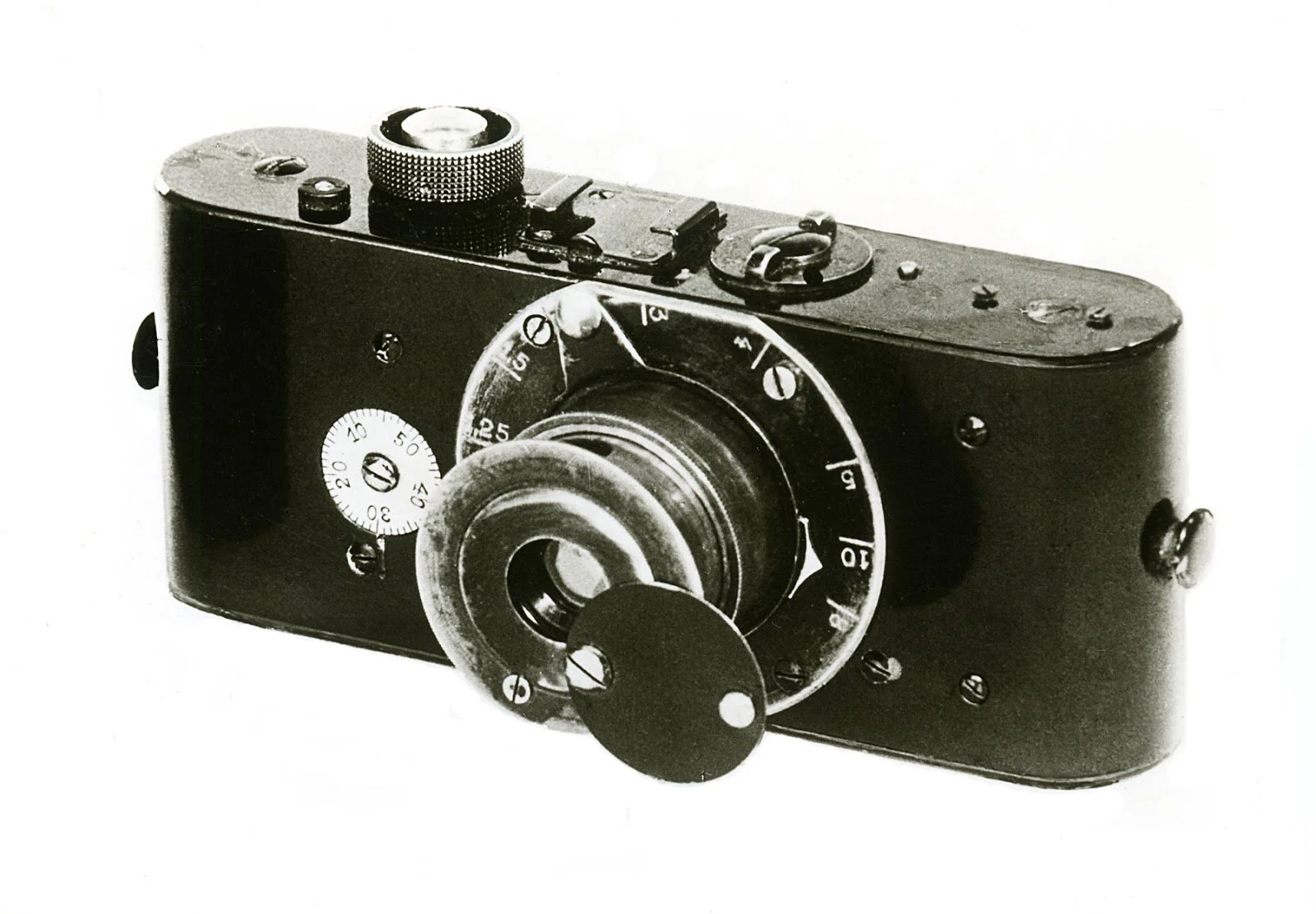 Black and white photograph of a vintage camera with a circular lens and dials for settings