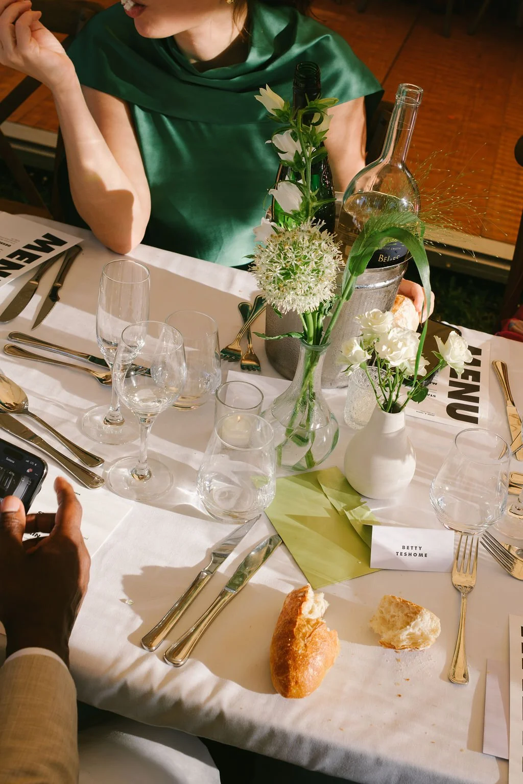 A formal dinner table set with multiple empty wine glasses, silverware and plates.