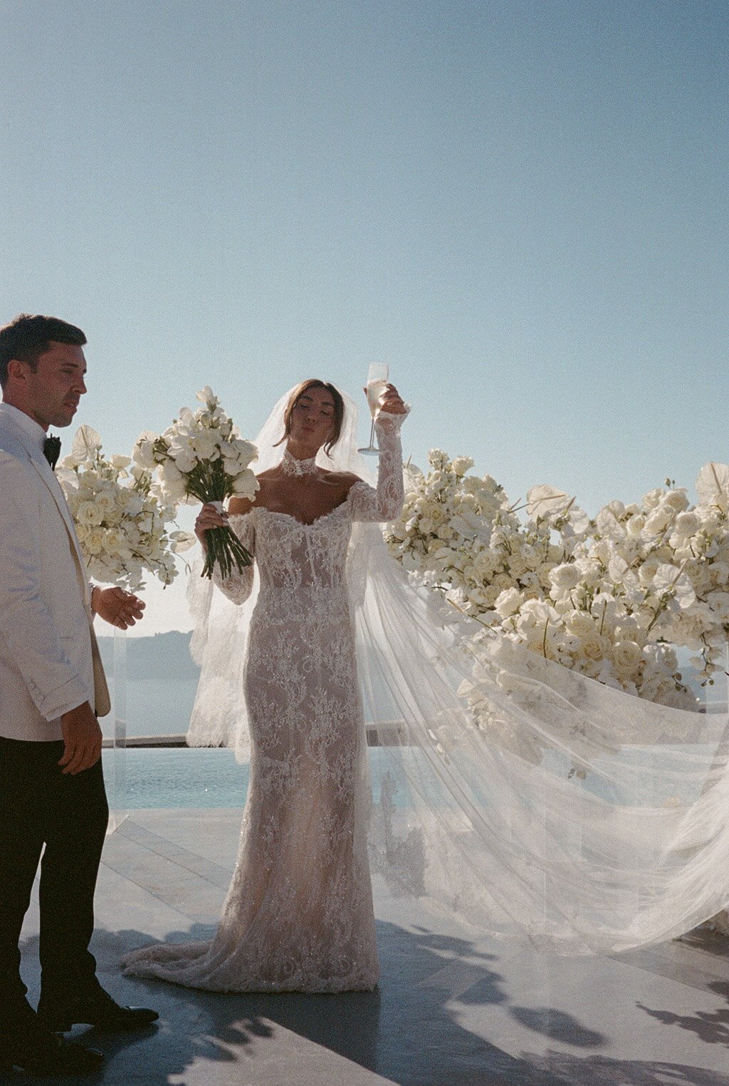 Bride and groom at outdoor wedding ceremony with floral arrangement.