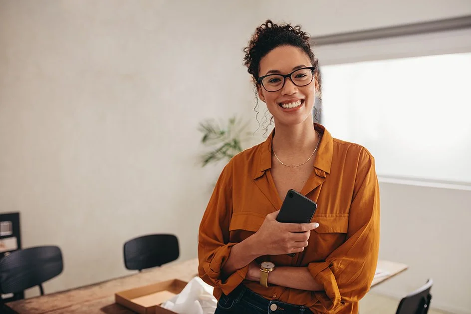 Smiling small business owner in a professional setting, reflecting the positive results of working with Boosted Pathways on tailored solutions for sustainable growth.