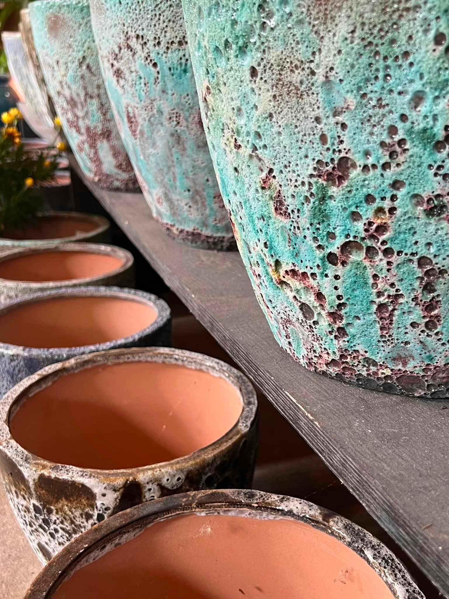 A shelf full of large ceramic planters.