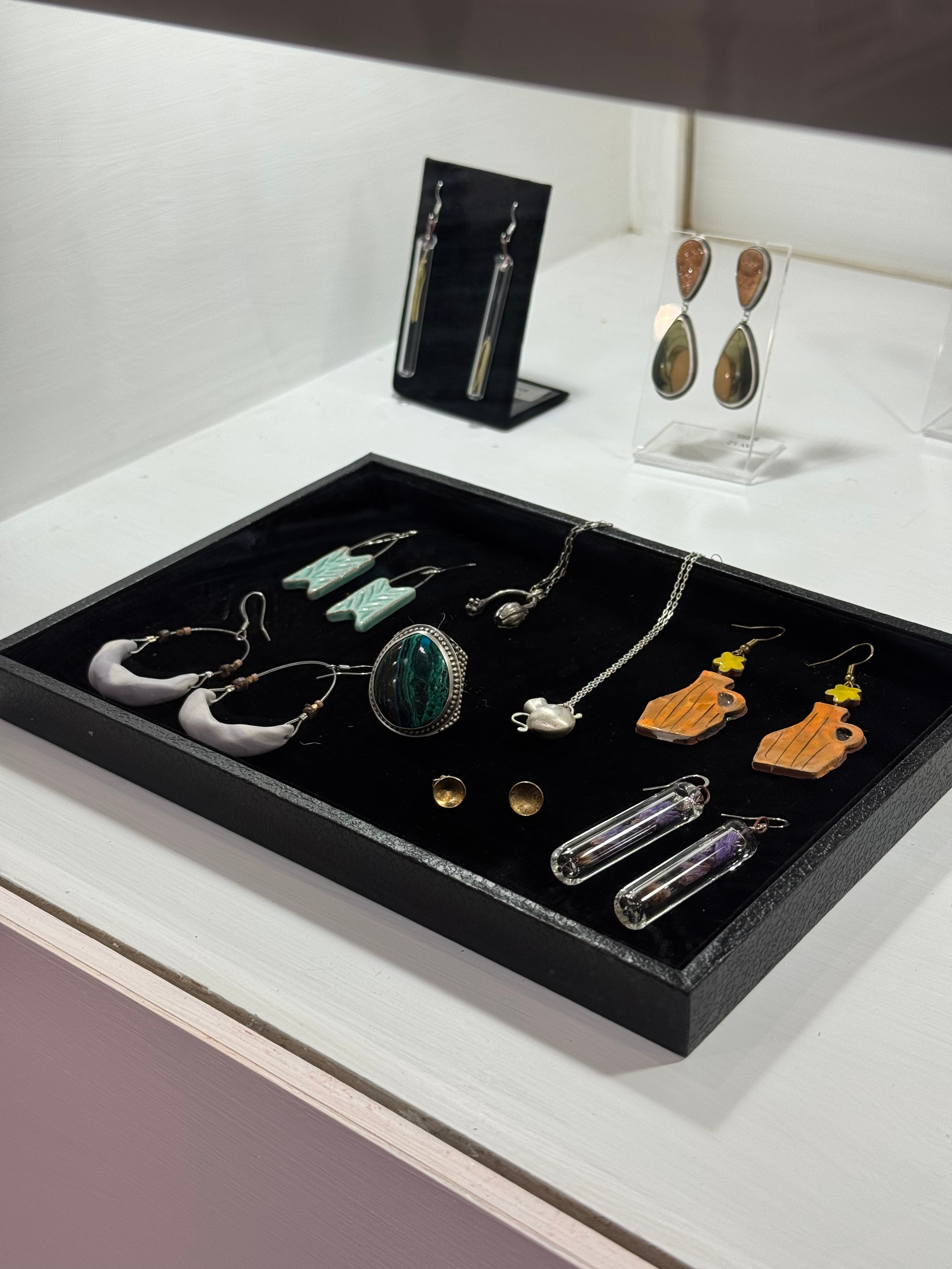 Display of earrings, necklaces, and jewelry accessories in a store showcase.