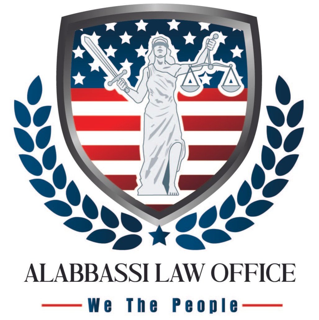 A logo with a shield featuring Lady Justice holding a sword and scales, with an American flag background, surrounded by laurel leaves. Below the shield, it says 'ALABBASSI LAW OFFICE' and 'We The People'.