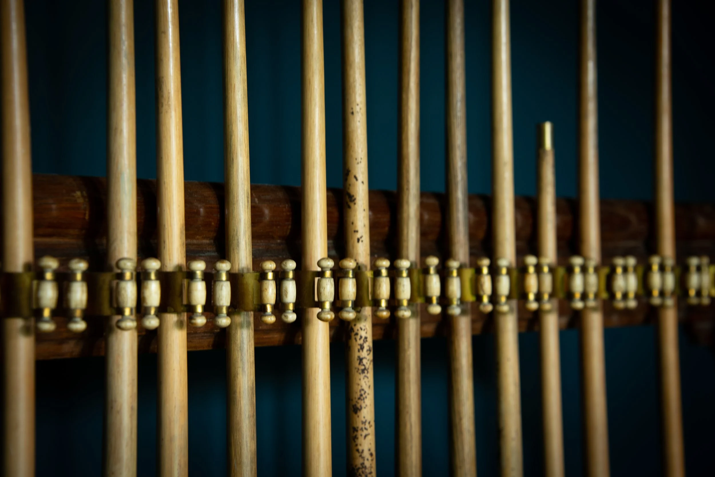 Close-up of a vintage wooden xylophone with light-colored keys and dark frame, against a dark background.
