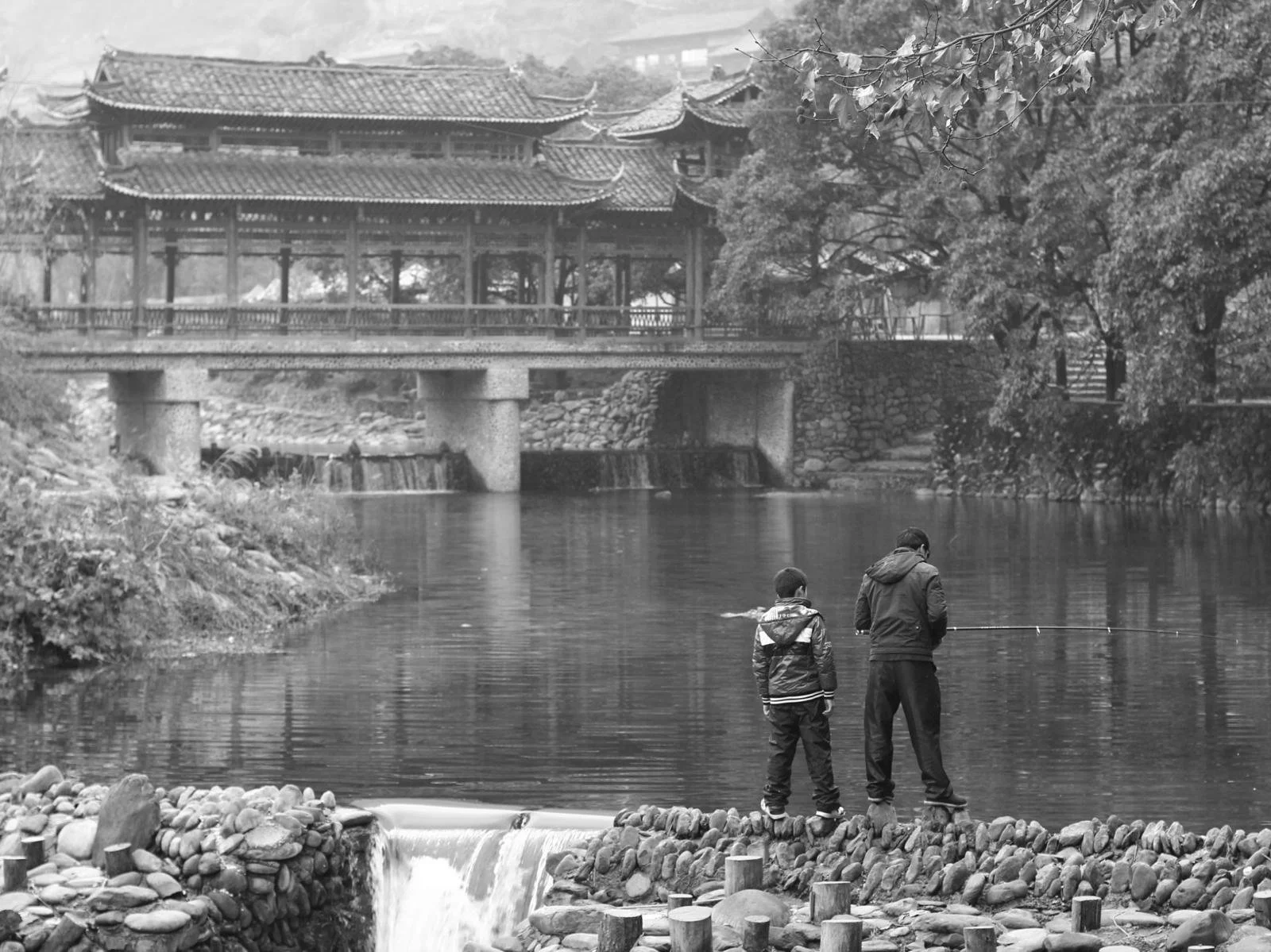 Father and son fishing together on a dam in Kaili, China.