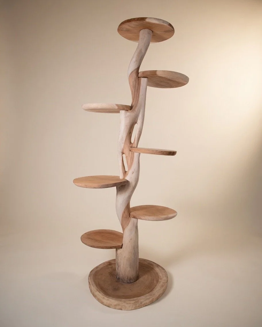 Tall wooden cat tree or plant display stand.