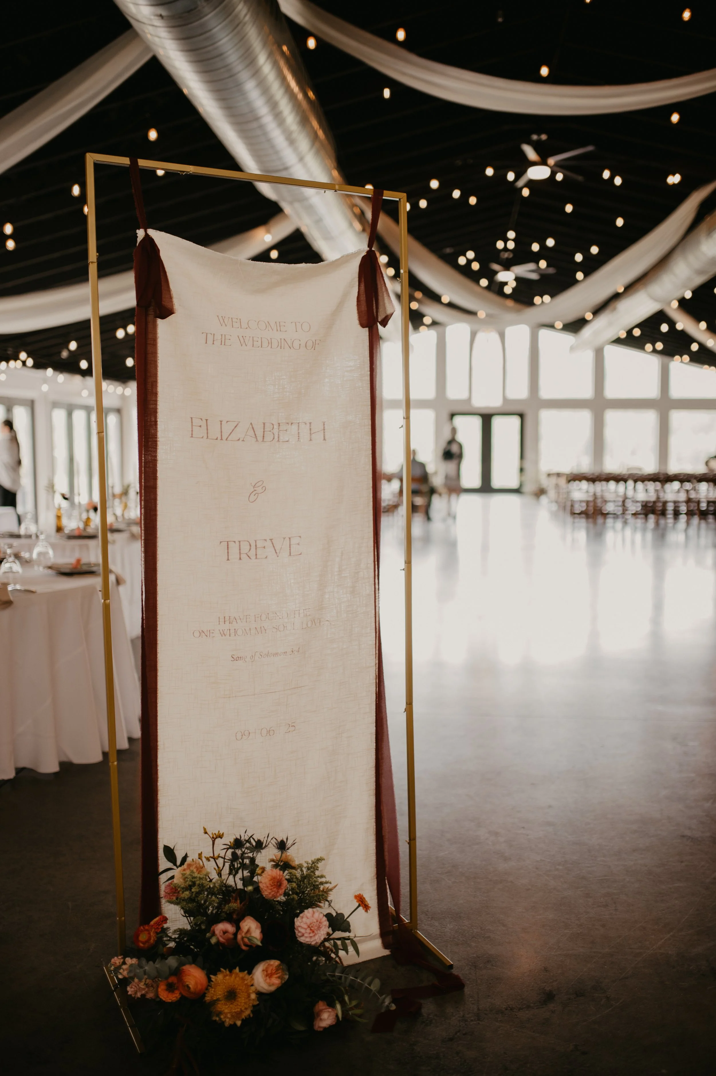 Wedding welcome sign with floral arrangement at The Shiloh wedding venue in North Carolina