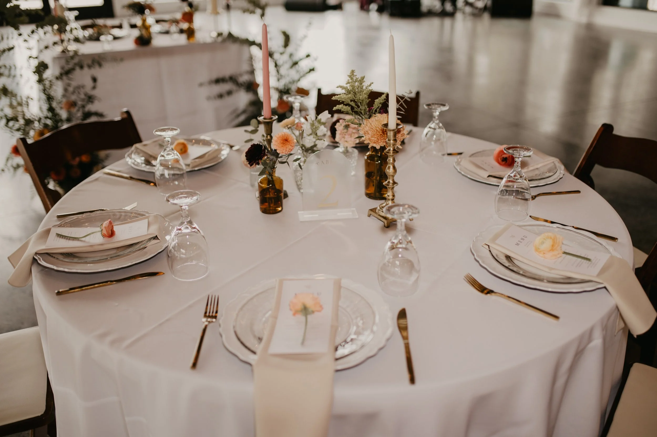 “Wedding reception table with bud vase centerpieces, taper candles, and romantic moody summer florals in North Carolina