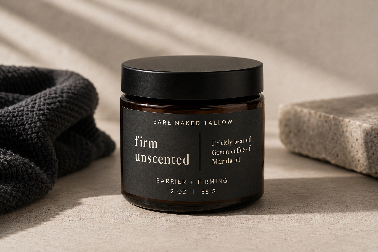 A dark brown jar of Bare Naked Tallow Firm Unscented Brightening & Collagen skincare cream with a black lid, placed on a rustic wooden surface with rocks and dried plants around it.