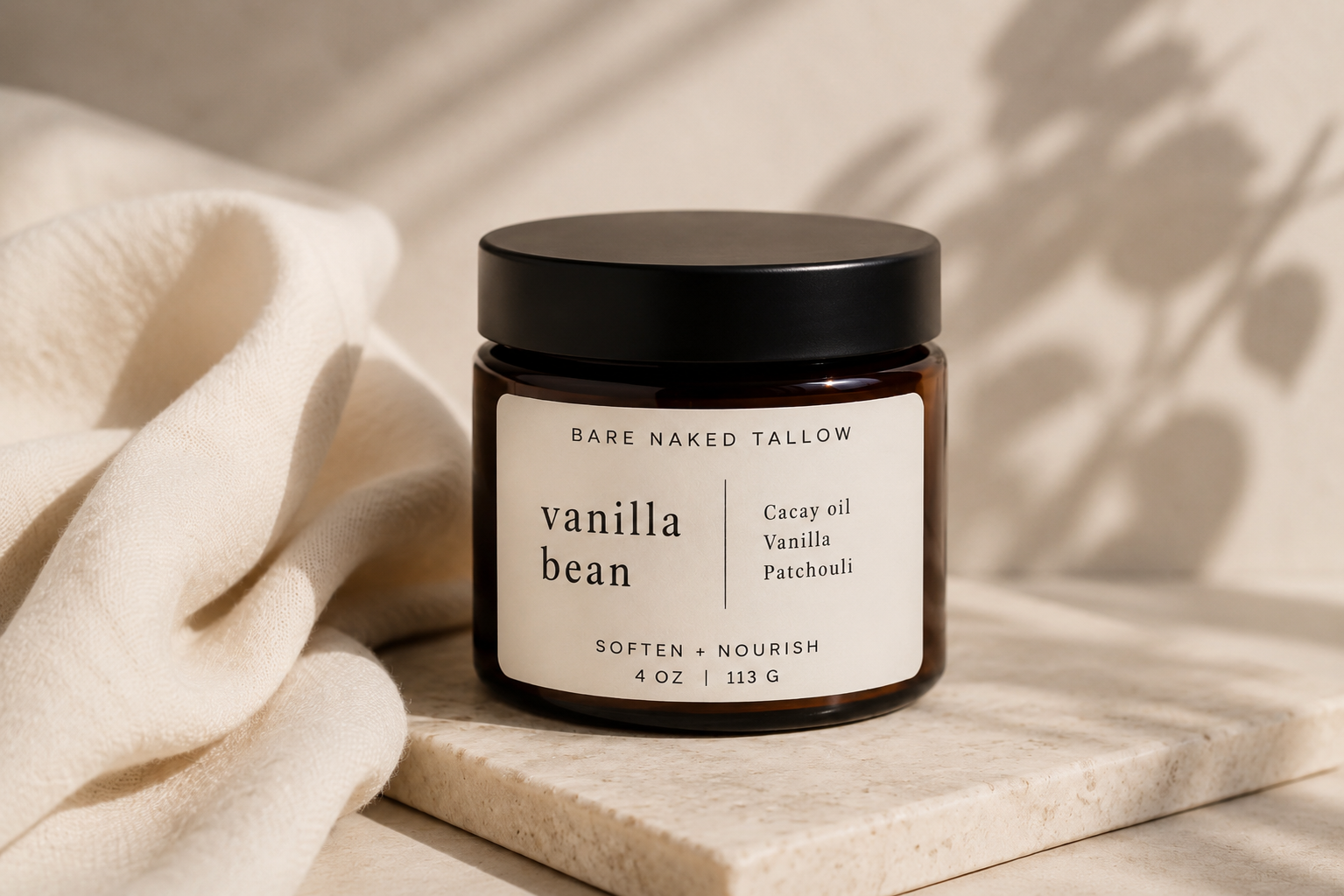 A jar of Vanilla Bean from Bare Naked Tallow on white satin fabric.