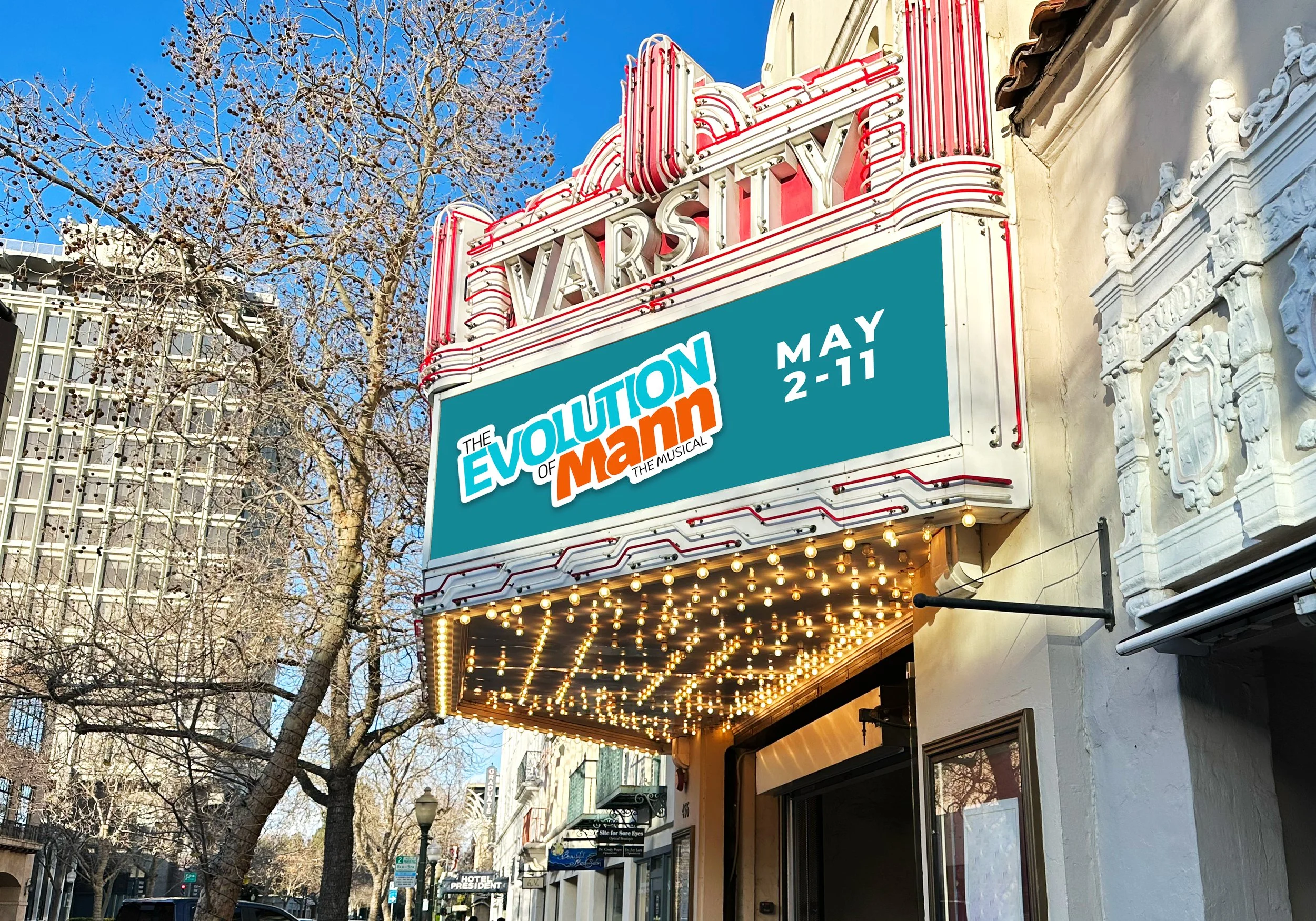 Marquee sign for the musical 'The Evolution of Mom' at the historic Varsity theater, advertising shows from May 2 to 11, with string lights illuminating the theater entrance. Bare trees and buildings line the street on a clear day.