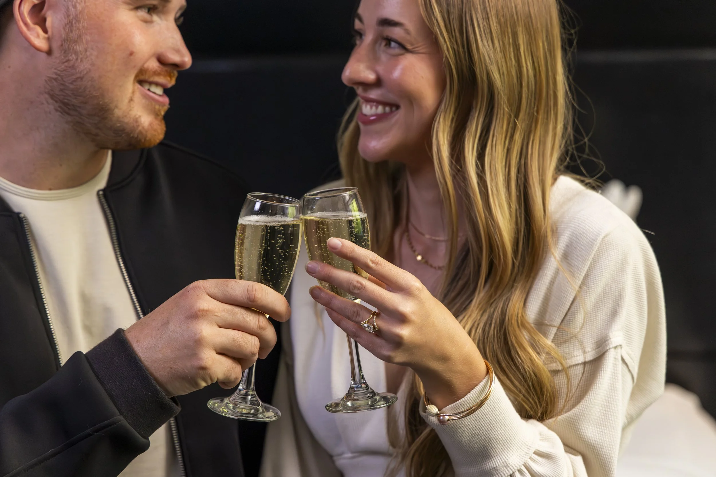 A couple celebrating with champagne, smiling and looking at each other.
