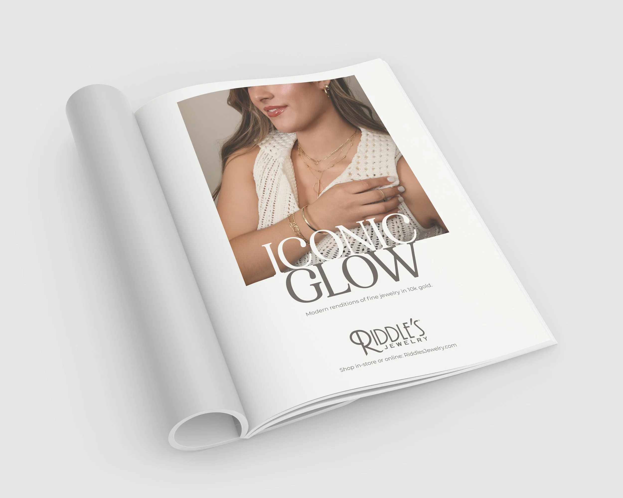 Open magazine showcasing jewelry with a woman wearing gold necklaces and bracelets on the cover.