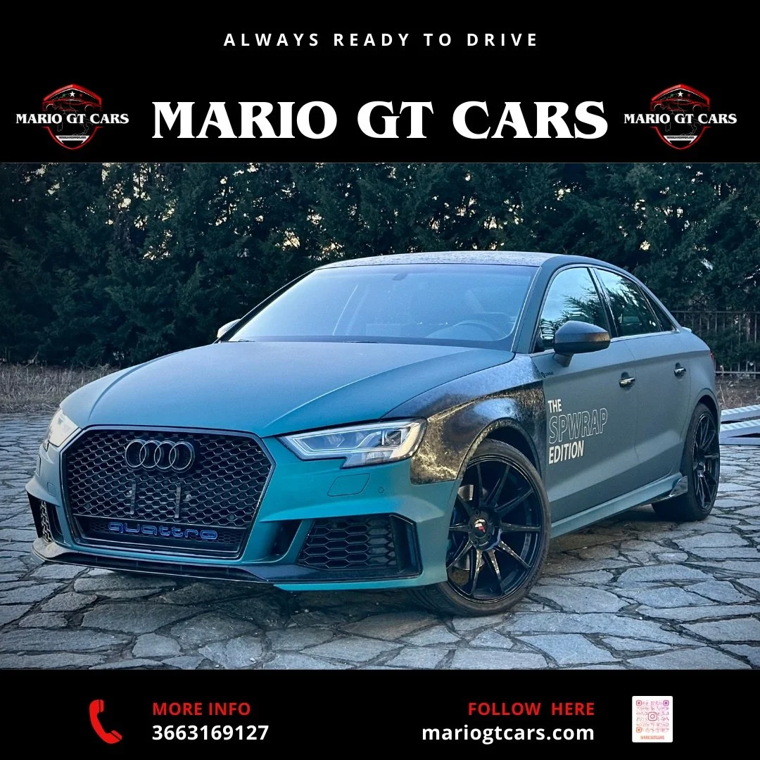 Auto Audi S4 sportiva di colore grigio con testi "The SPWRAP Edition" sulla portiera, parcheggiata su una strada di pietre, con uno sfondo di alberi e un cielo sereno.