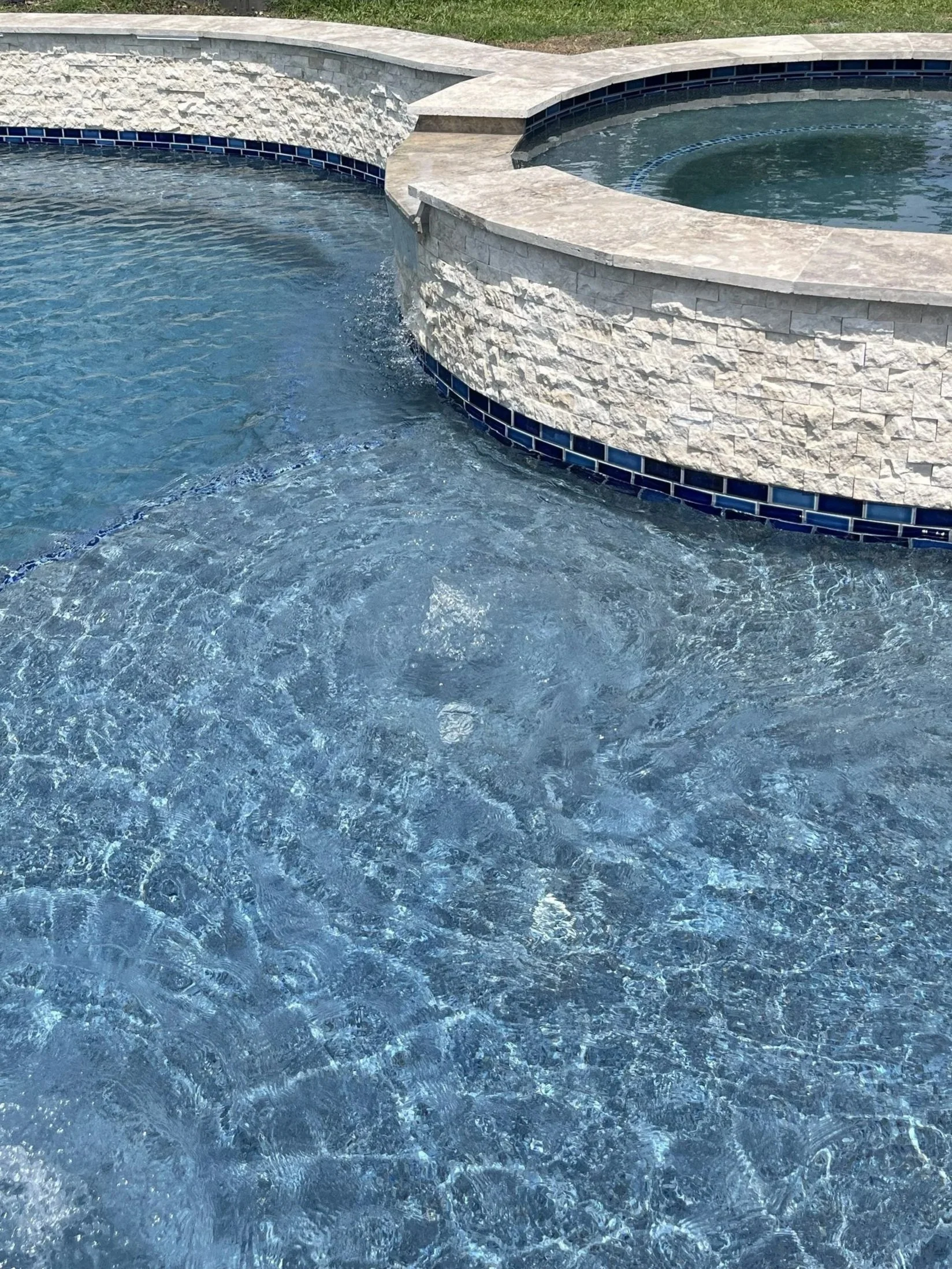 Silverlake in Pearland new construction swimming pool and spa with stone and tile detail, water feature and tanning ledge