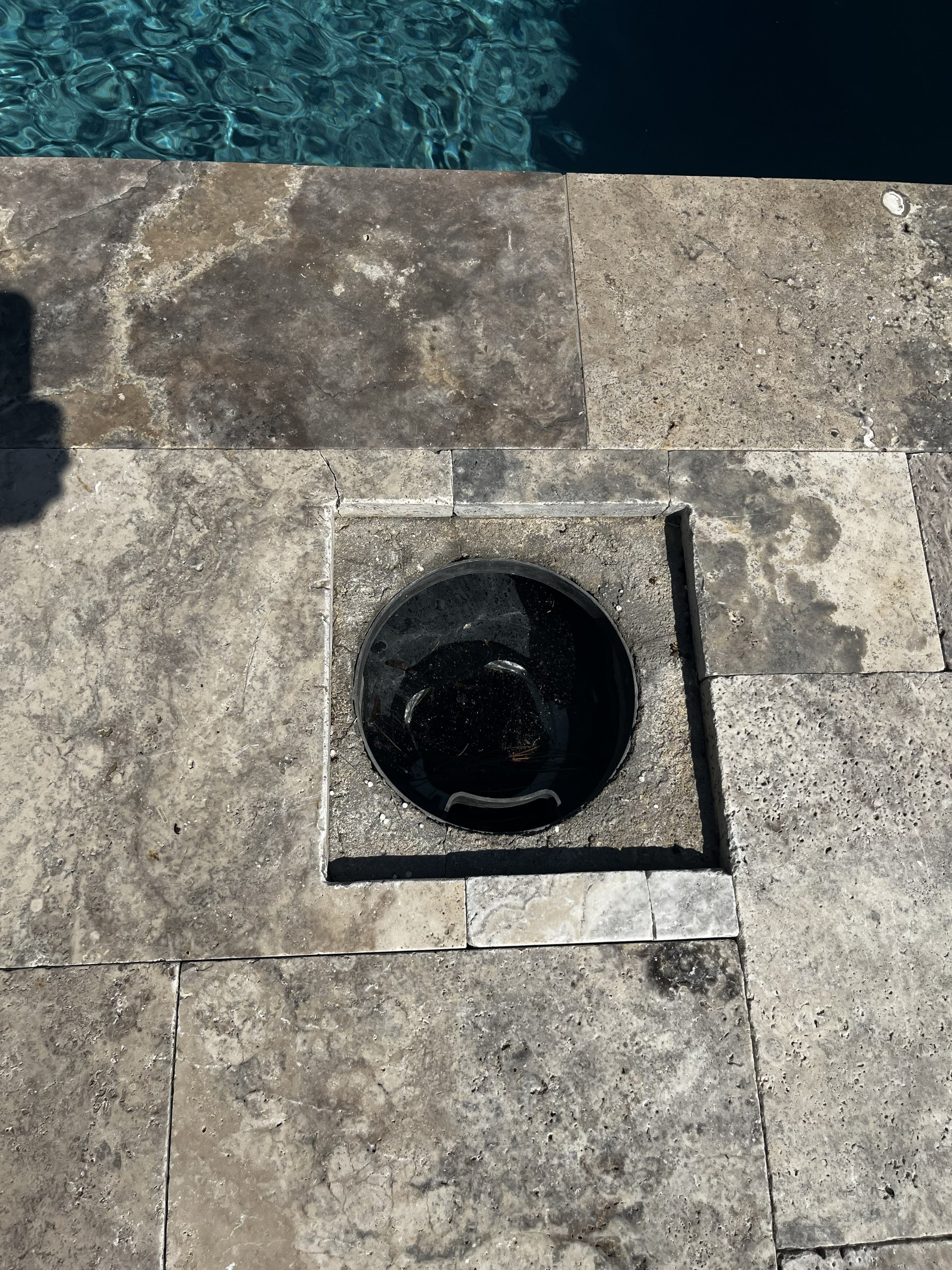 Stone skimmer cover removed to show the access opening and basket below