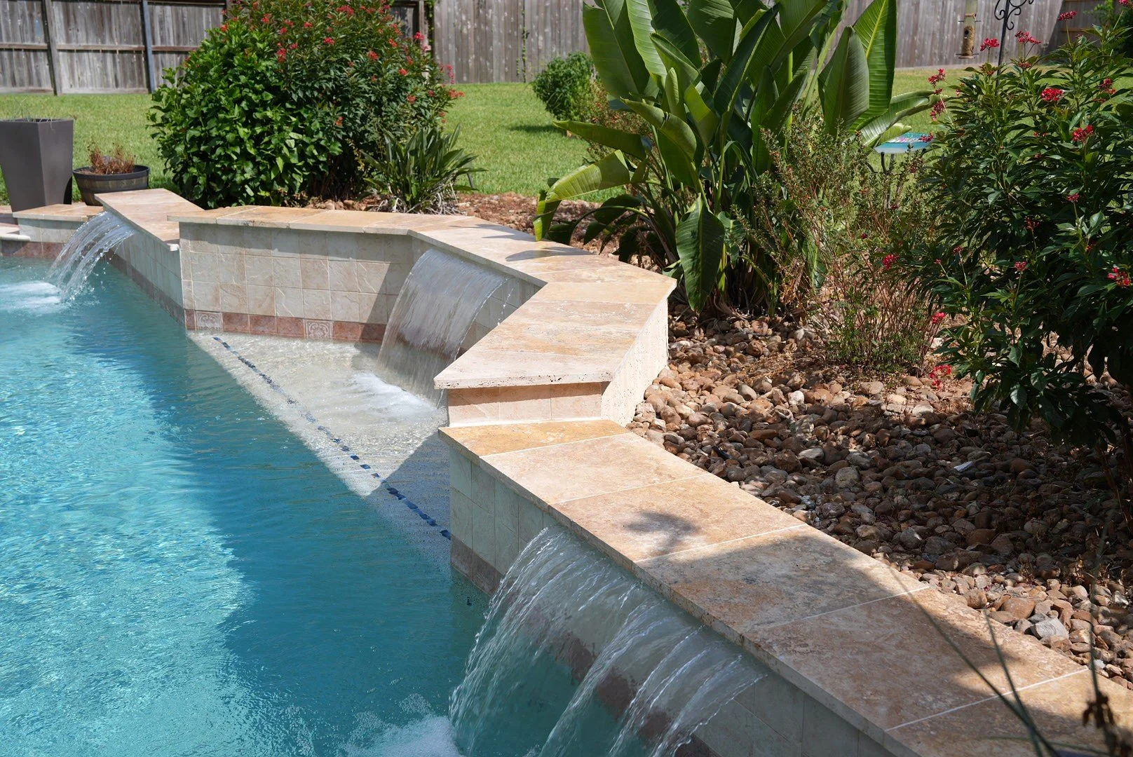 Raised pool wall with three sheer descent water features at the Carrington Oaks pool