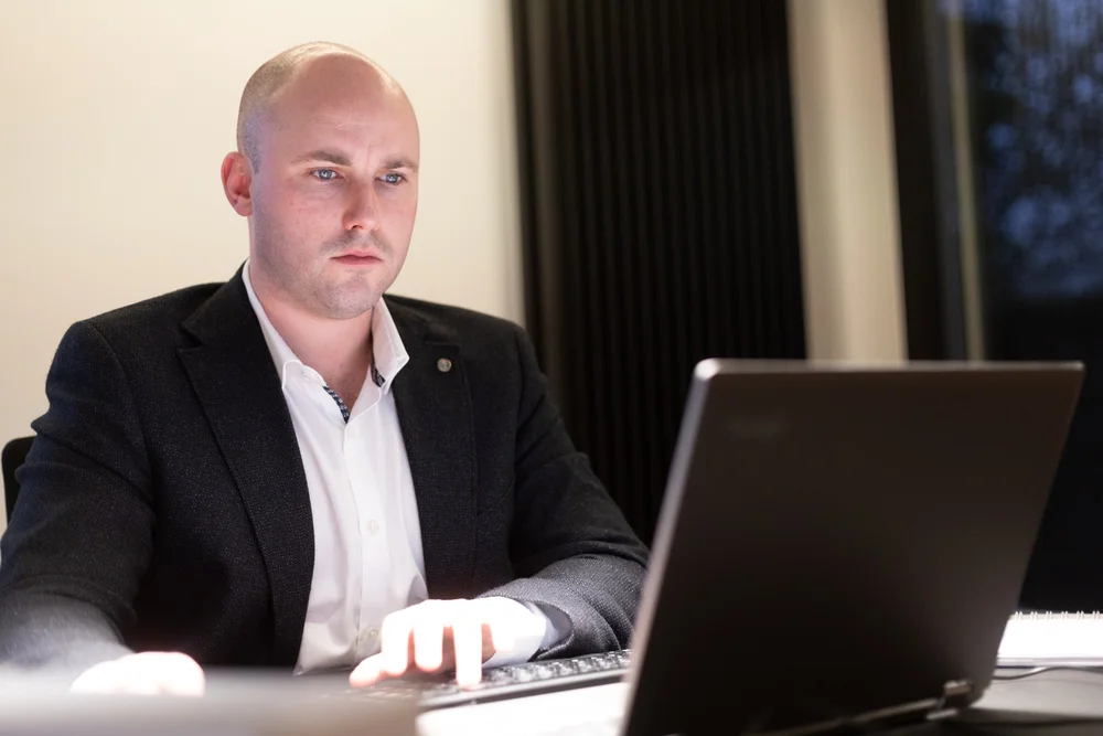 Man working on a laptop at a desk, focused