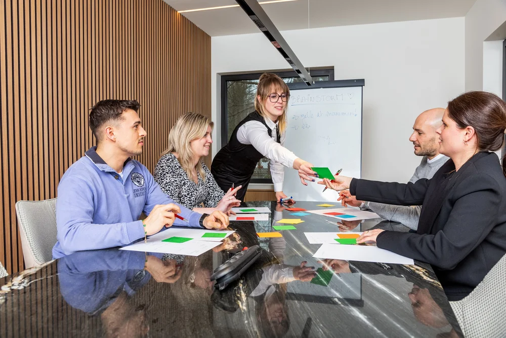 Colleagues gathered around a whiteboard during a brainstorming session