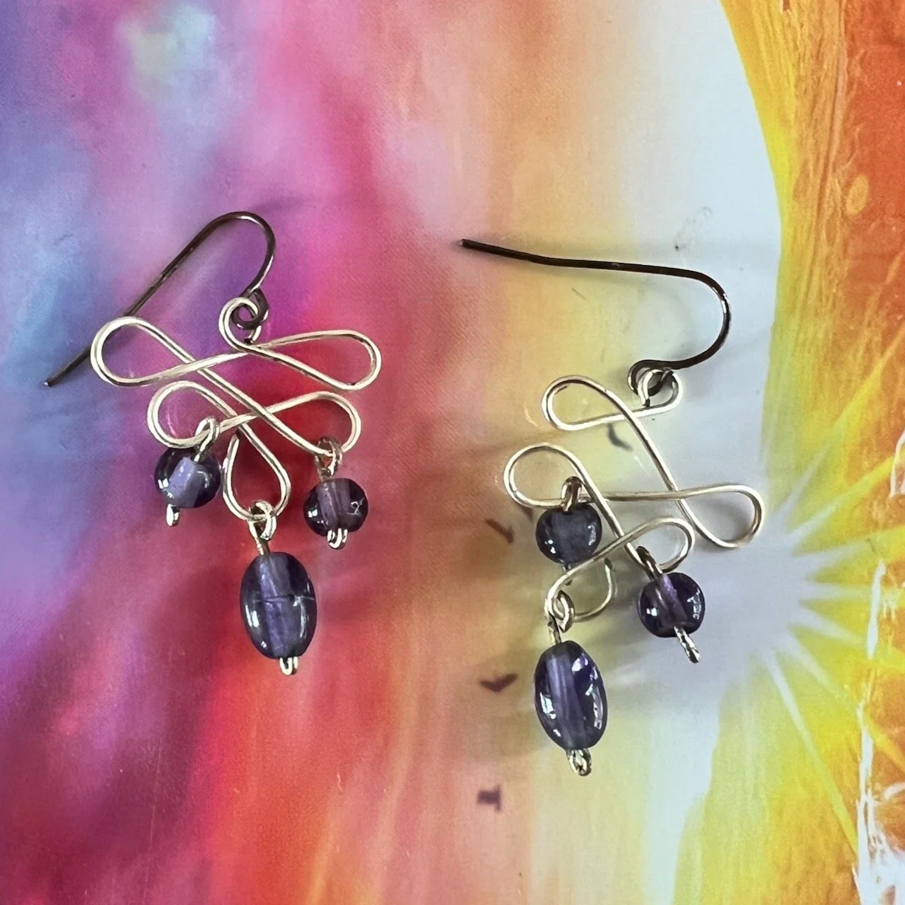 Silver tone wire sculpted earrings with amethyst beads