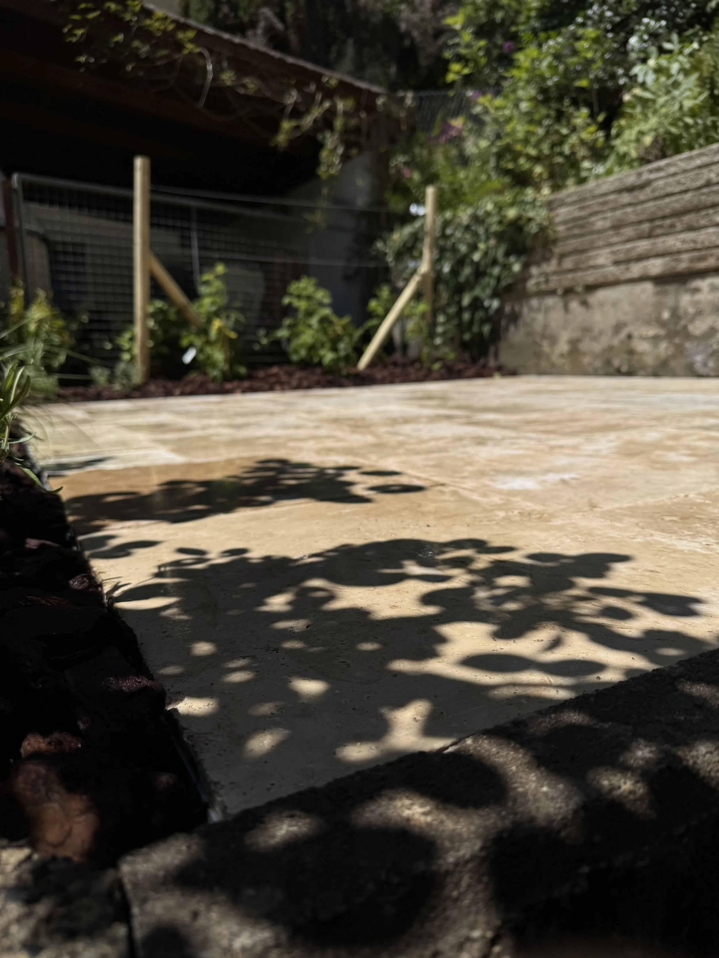 Sitzplatz aus Travertin Platten erstellt in einem Garten in Bern