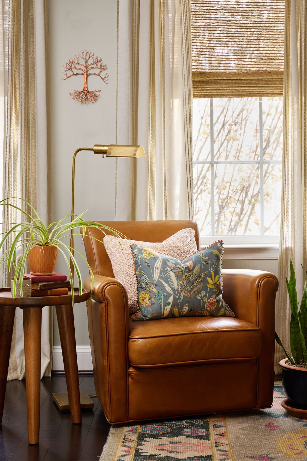living room with cinnamon-colored leather chair and soft, sheer drapery with strip pattern