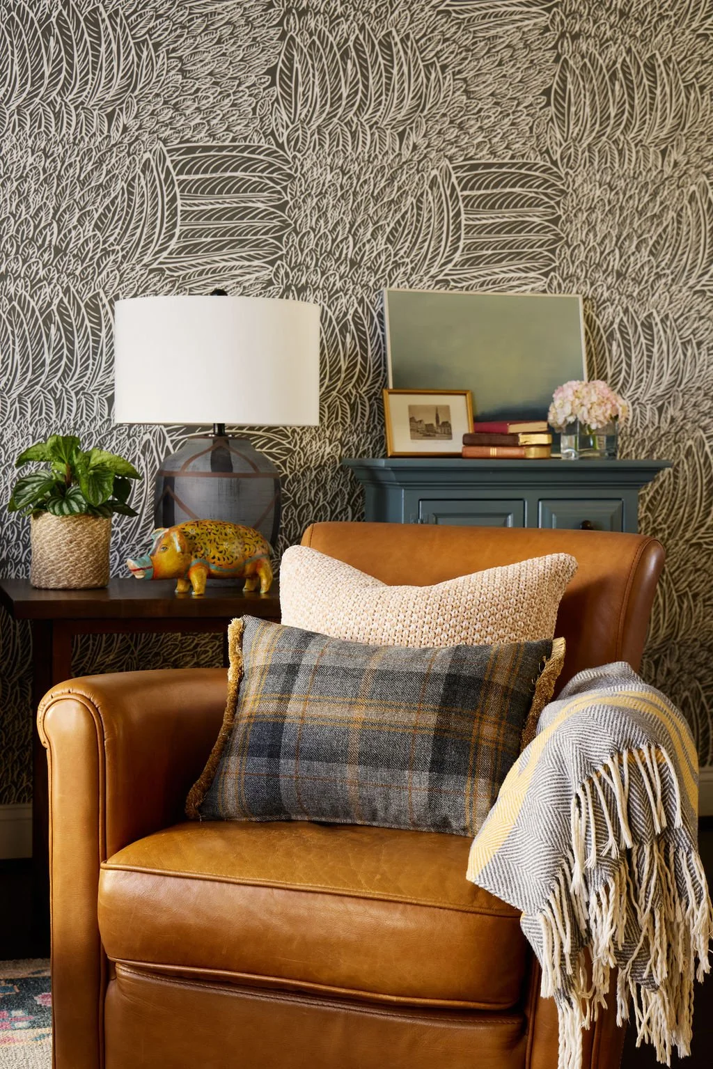 feather wallpaper and leather chair in boho living room