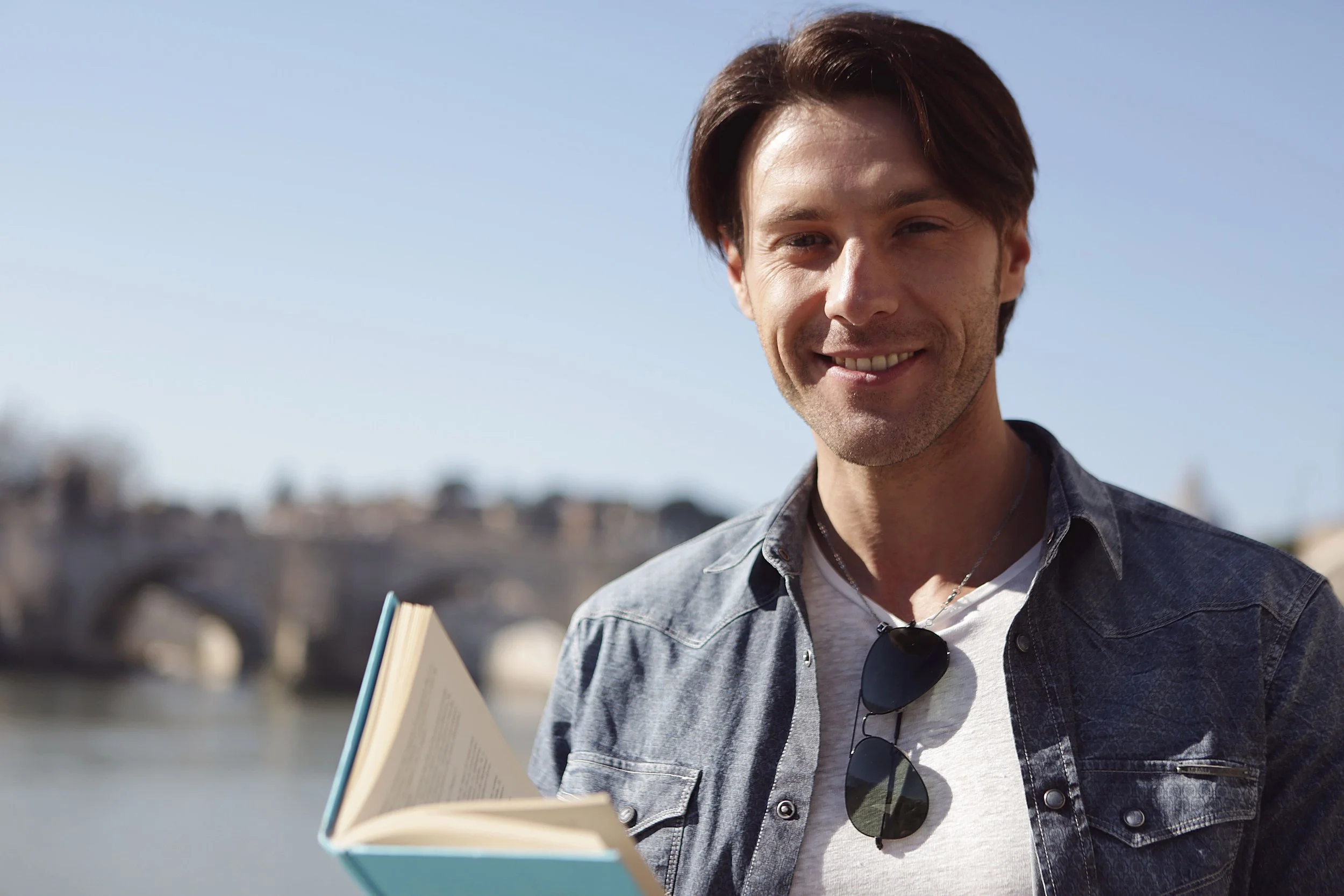 Smiling man in a denim jacket outdoors