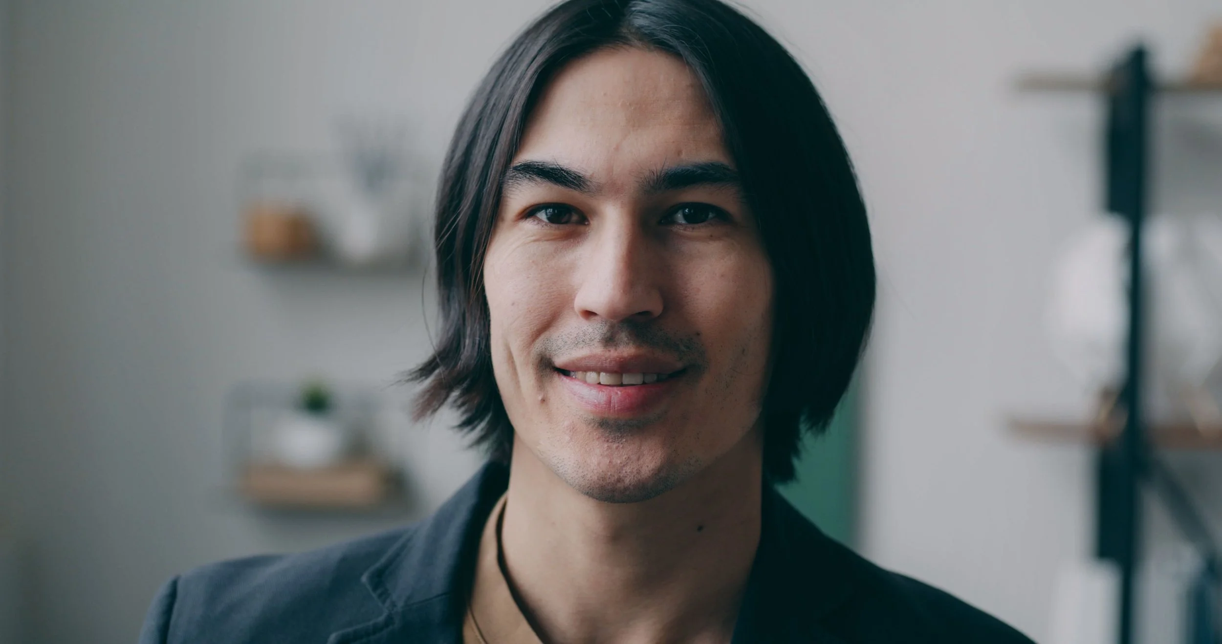 Smiling man with shoulder-length dark hair