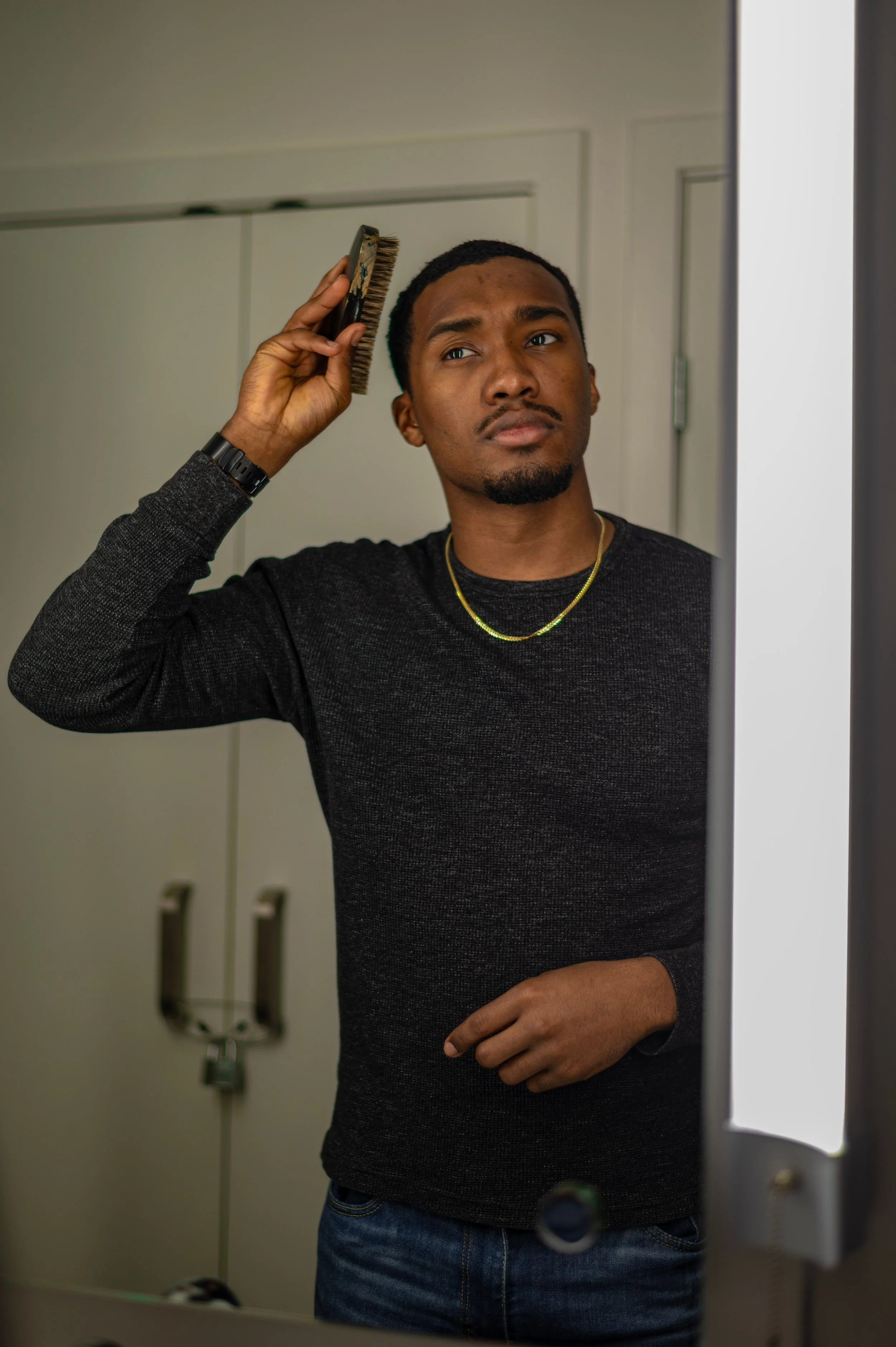 Man combing his hair in front of a mirror