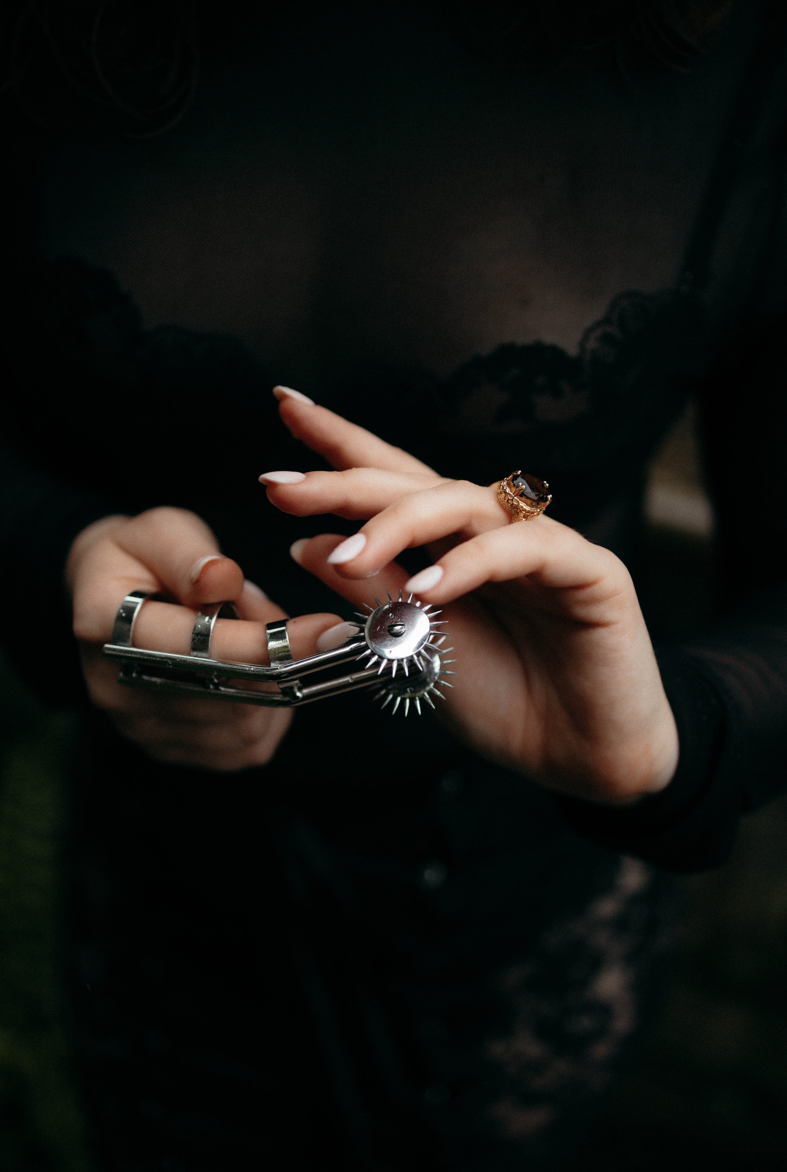 Hand with rings holding a metallic. Bespoke psychological power dynamics and mental release for high-profile leaders, executives, and founders. Absolute discretion and controlled catharsis in London.