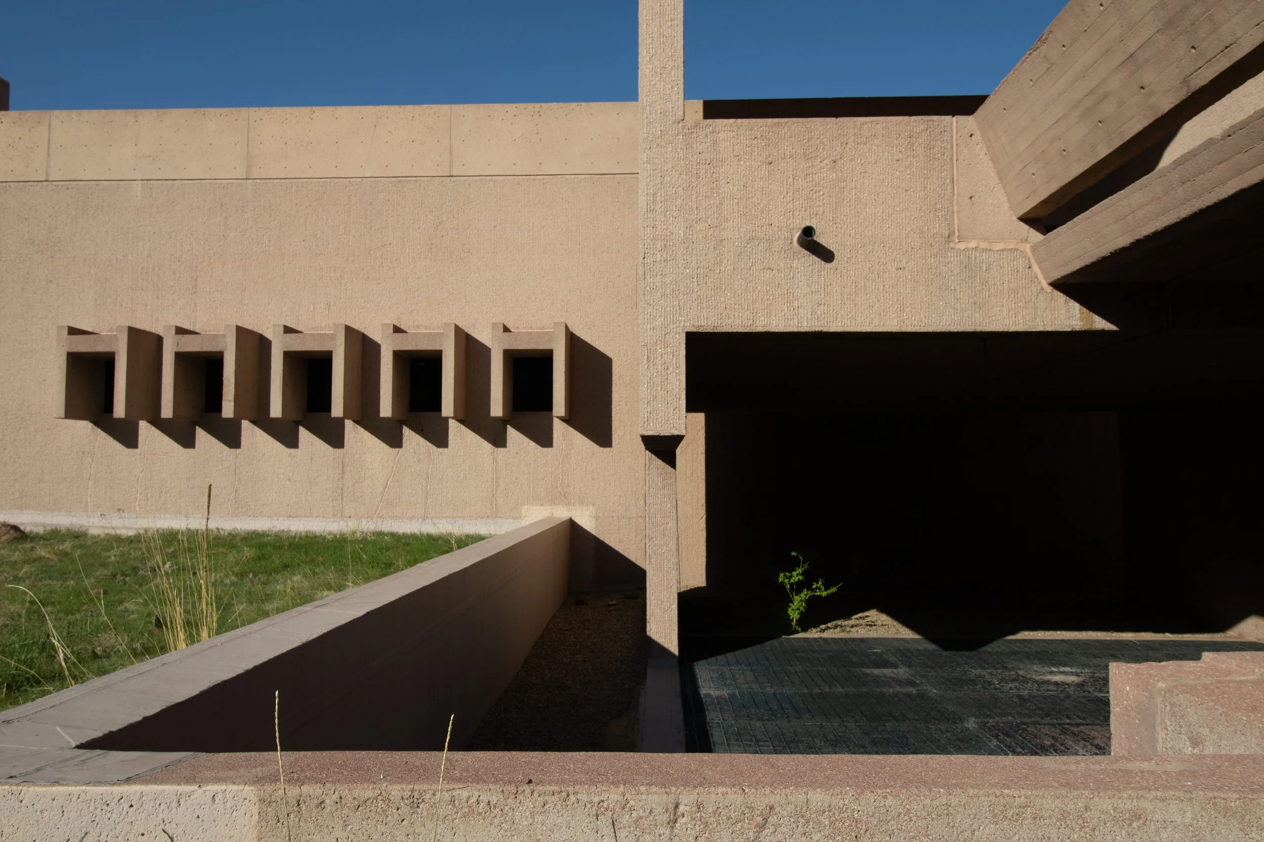 Row of deep-set rectangular openings casting triangular shadows on concrete wall, NSF NCAR Mesa Laboratory, Boulder, CO