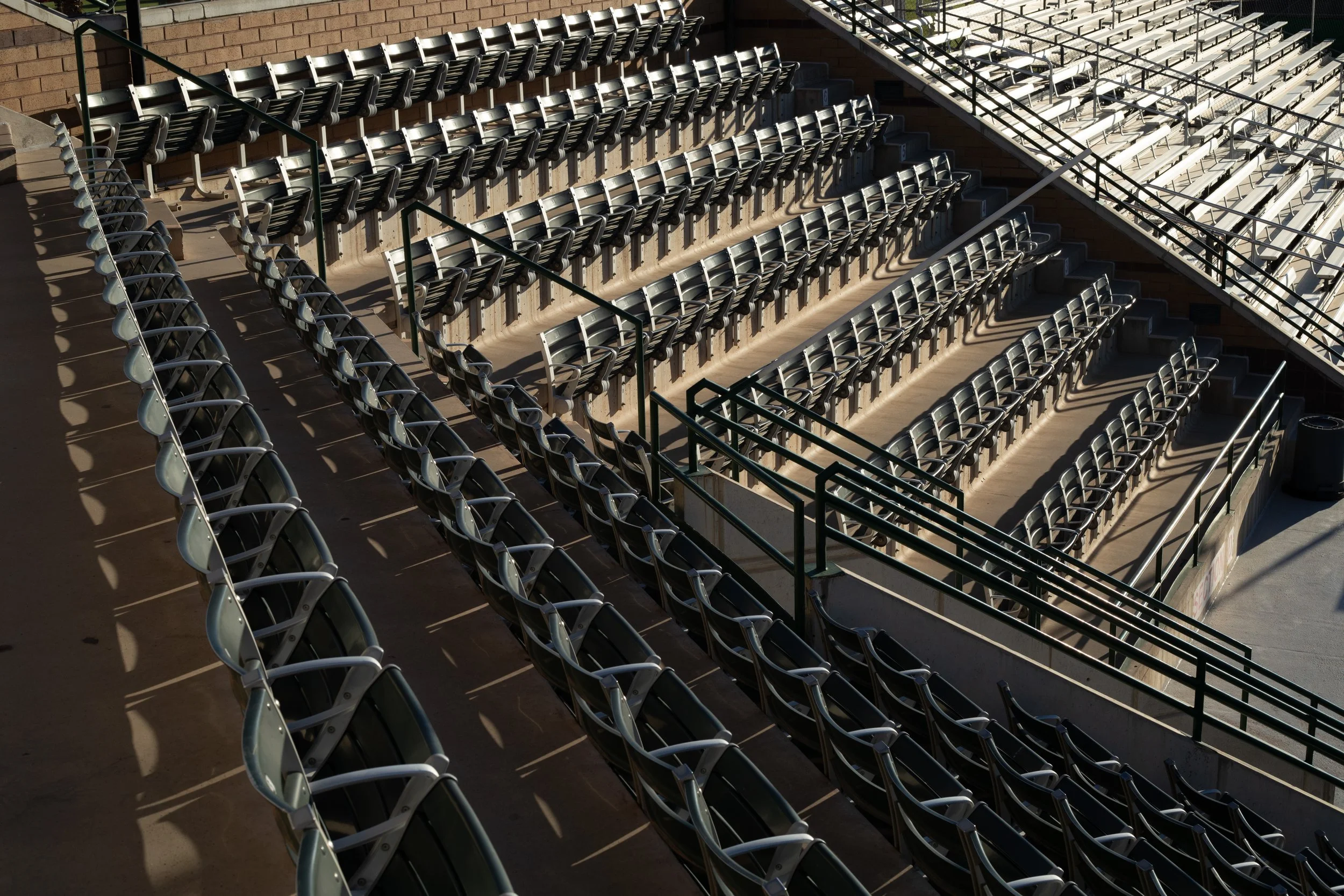 Rows of empty metal stadium seats casting shadows, Bruce Hurst Field, Utah Tech University, St. George, UT