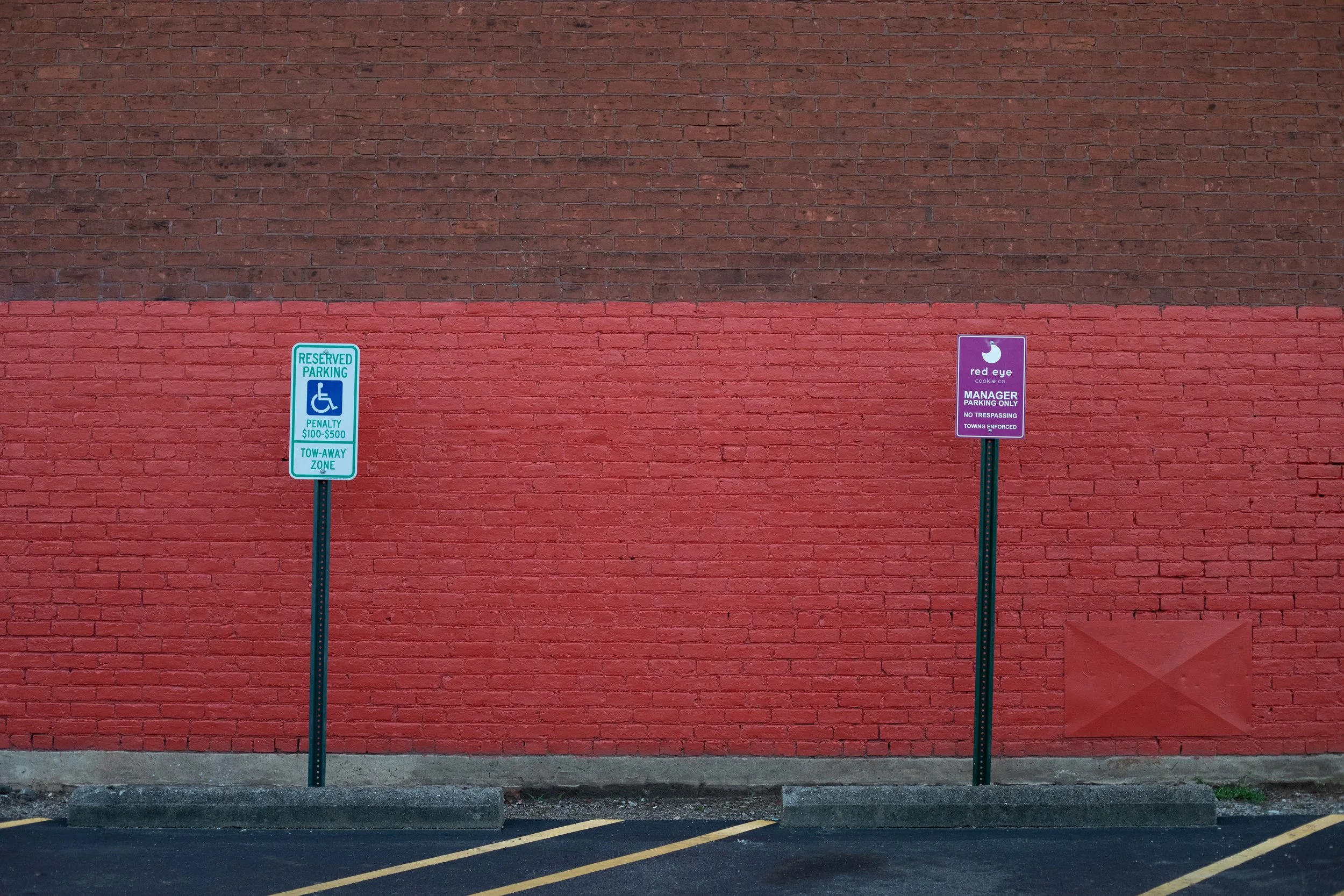 Two signs, two-tone wall, red painted brick, Richmond, VA