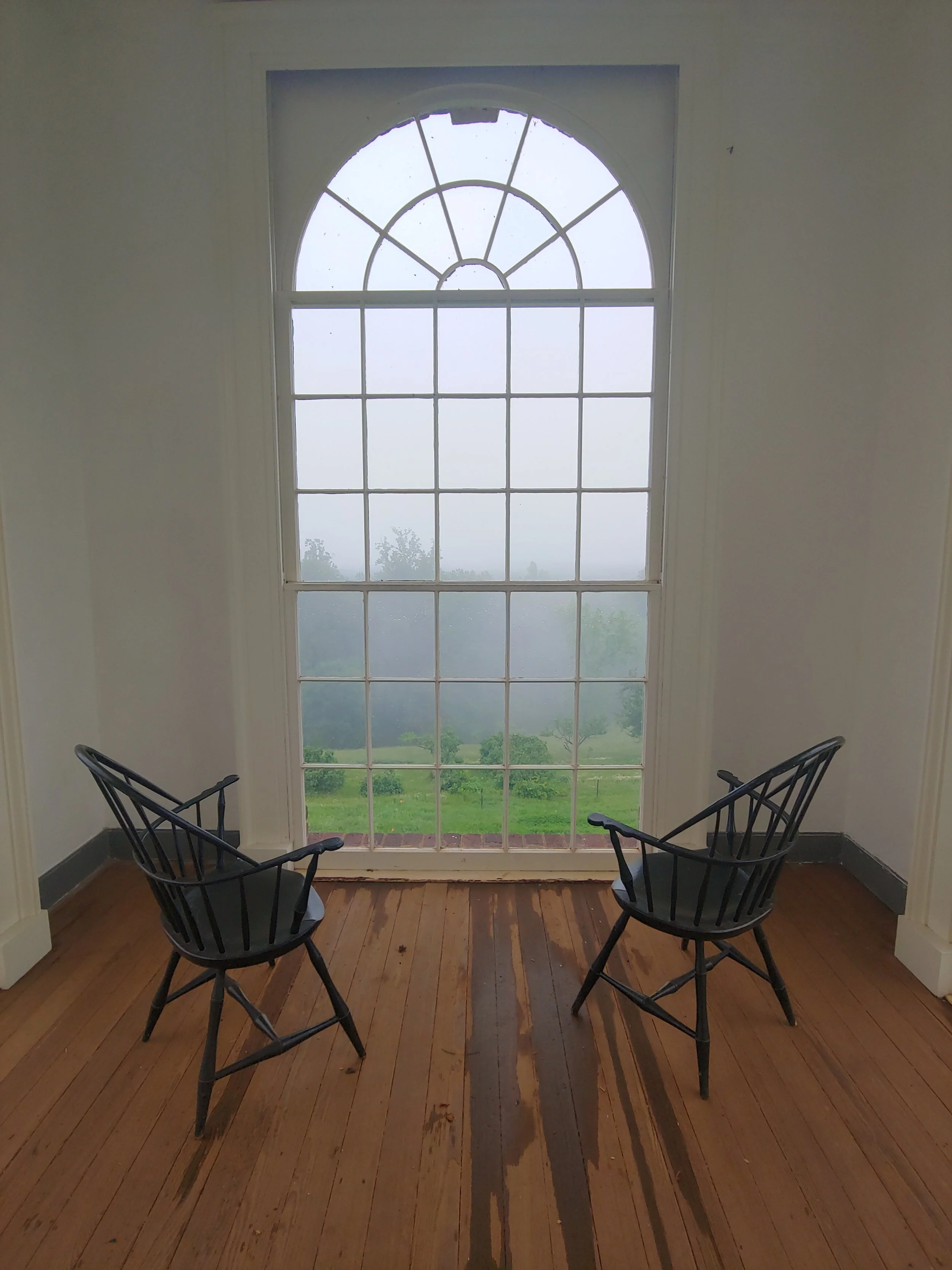 Two Windsor chairs, arched window, fog. Monticello, Virginia