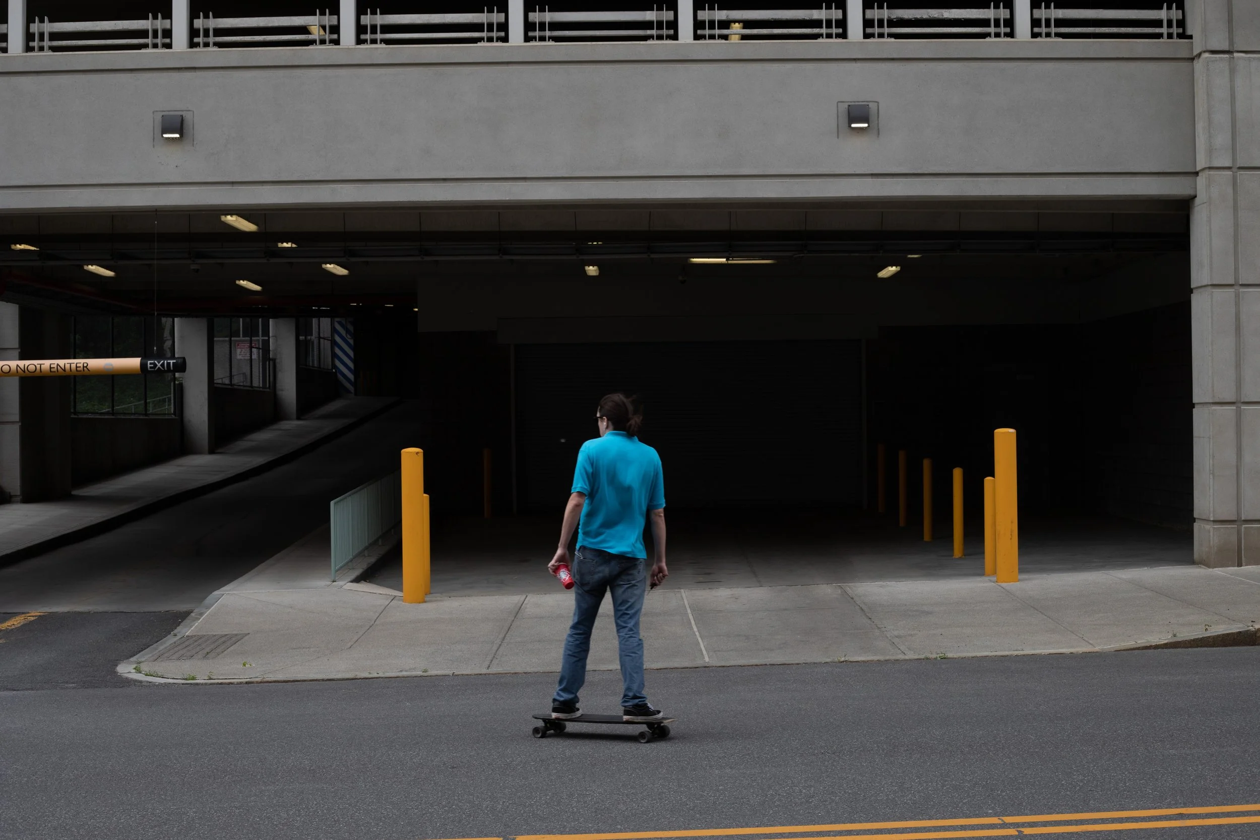 A skateboarder faces the mouth of a parking garage, Richmond, Virginia