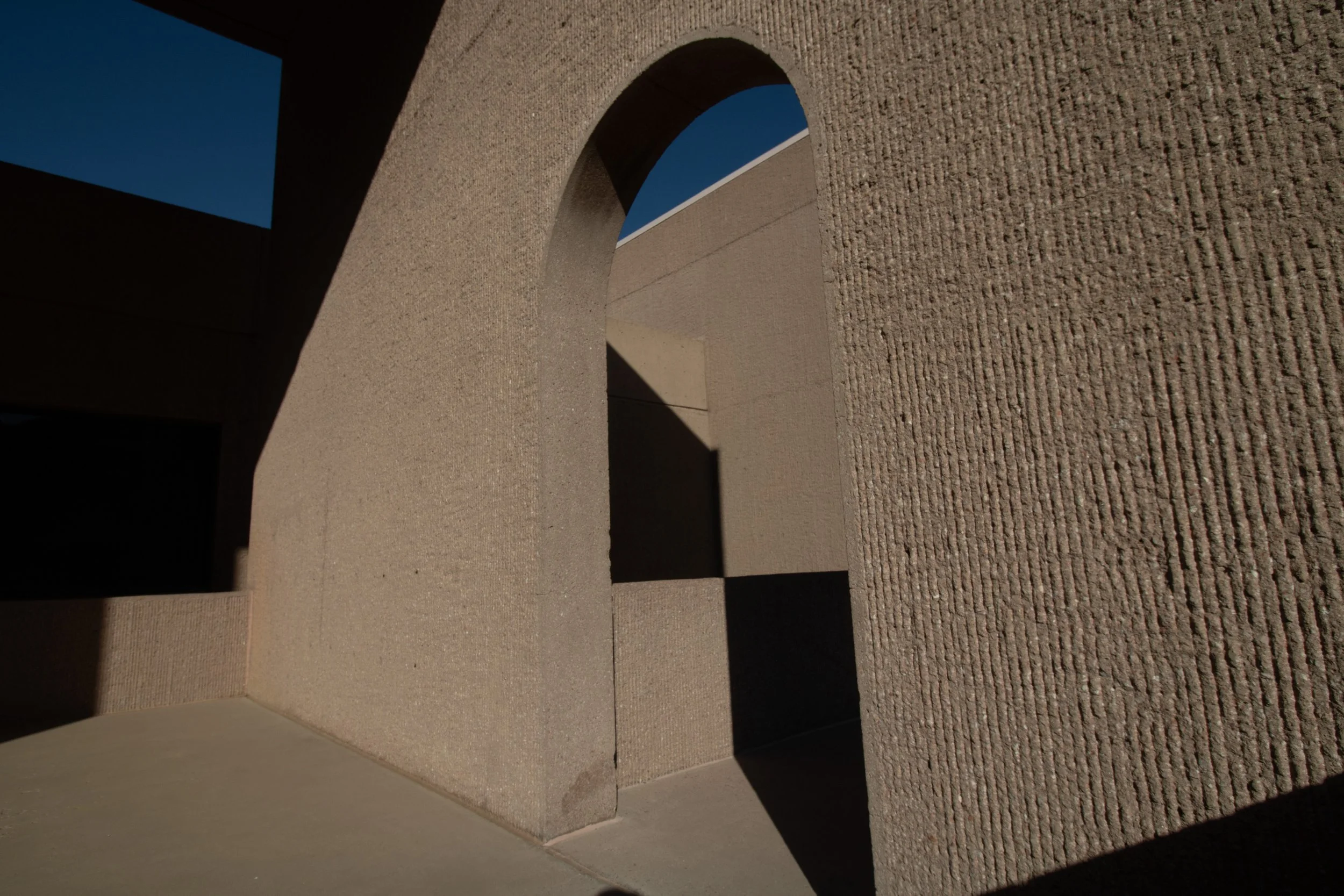 Arched opening in a rough concrete wall framing blue sky, NSF NCAR Mesa Laboratory, Boulder, CO