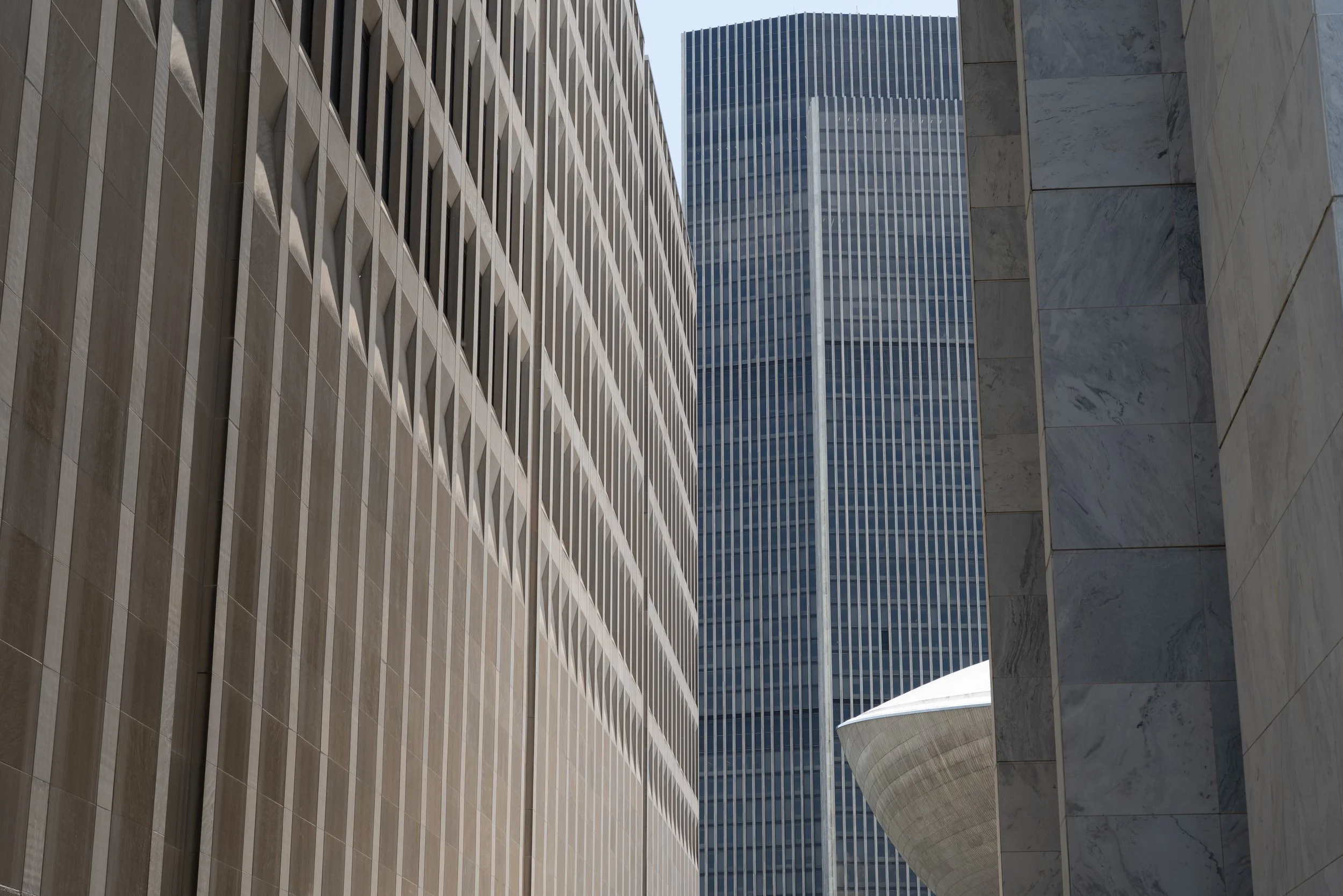 Vertical concrete fins, glass curtain wall, marble surface, The Egg, Albany, NY