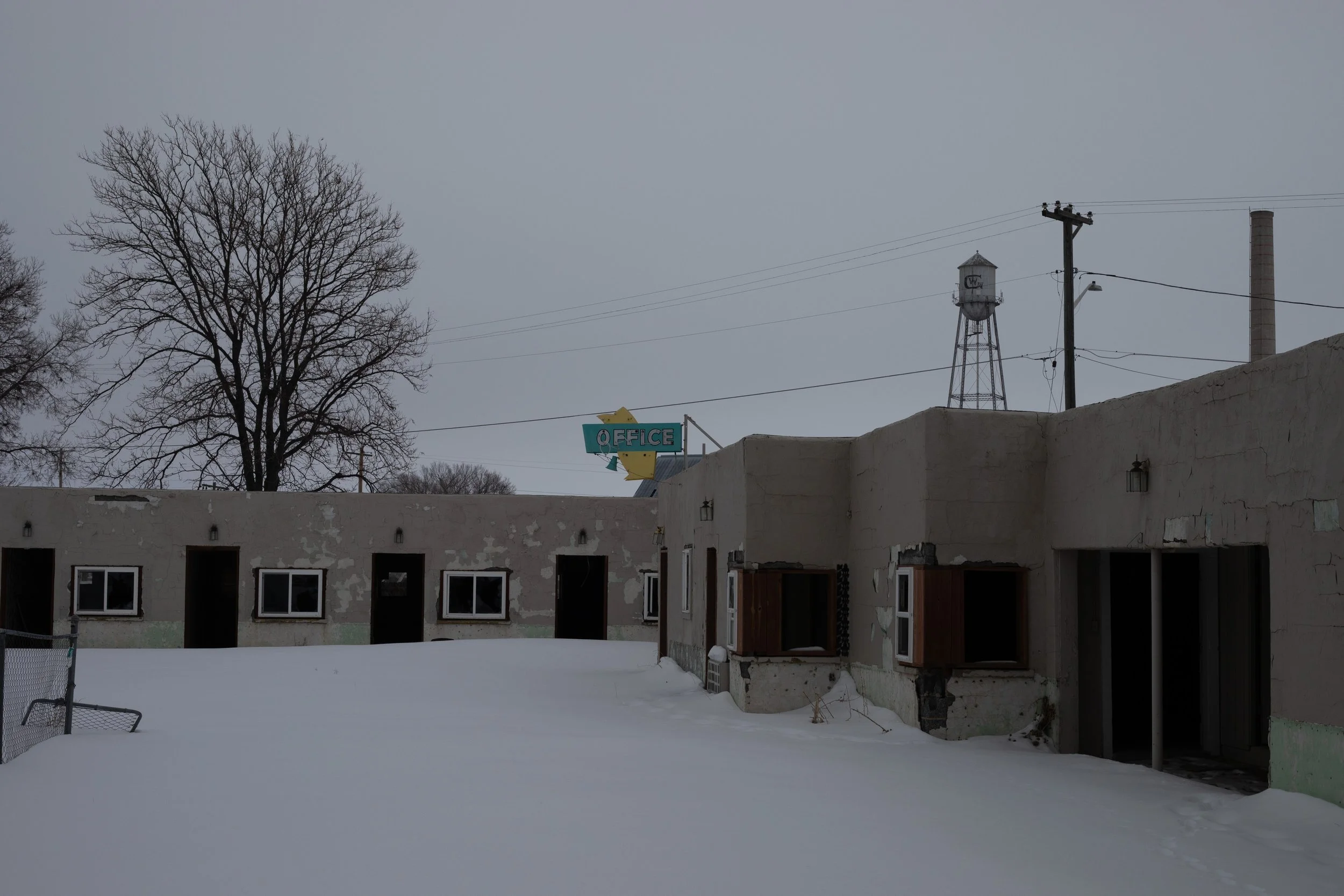 Abandoned roadside motel in snow, Office sign, water tower, Sterling, CO