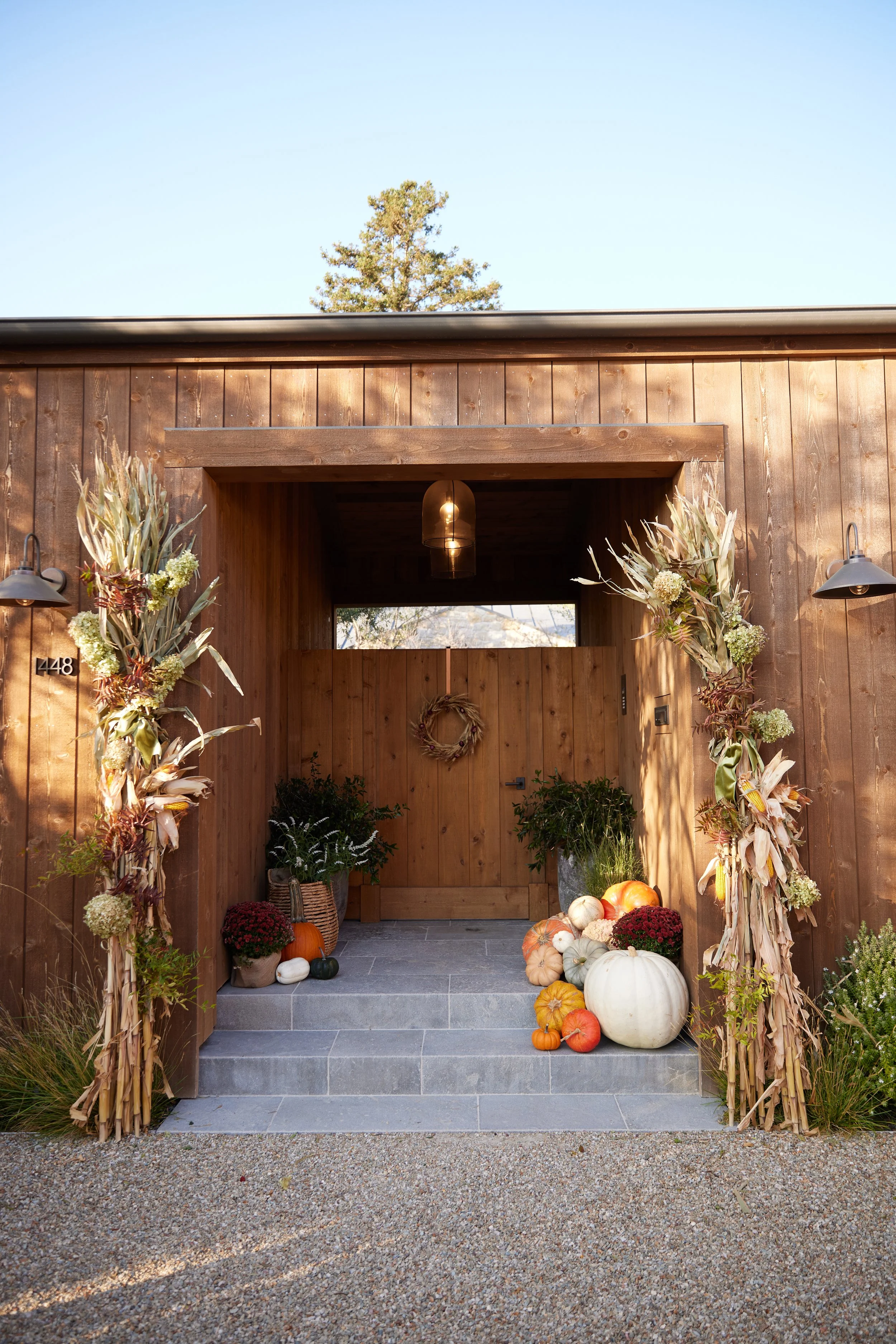 Our gorgeous porch styling with Garden Studio design. Cornstalks with limelight hydrangea, mums and pumpkins.