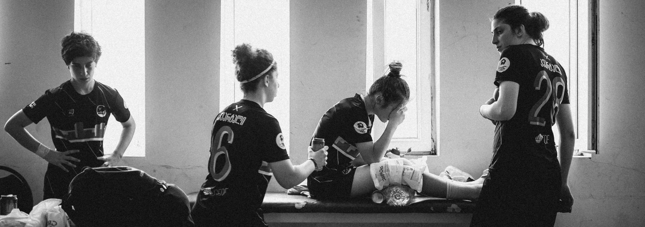 Injured striker being comforted by teammates.