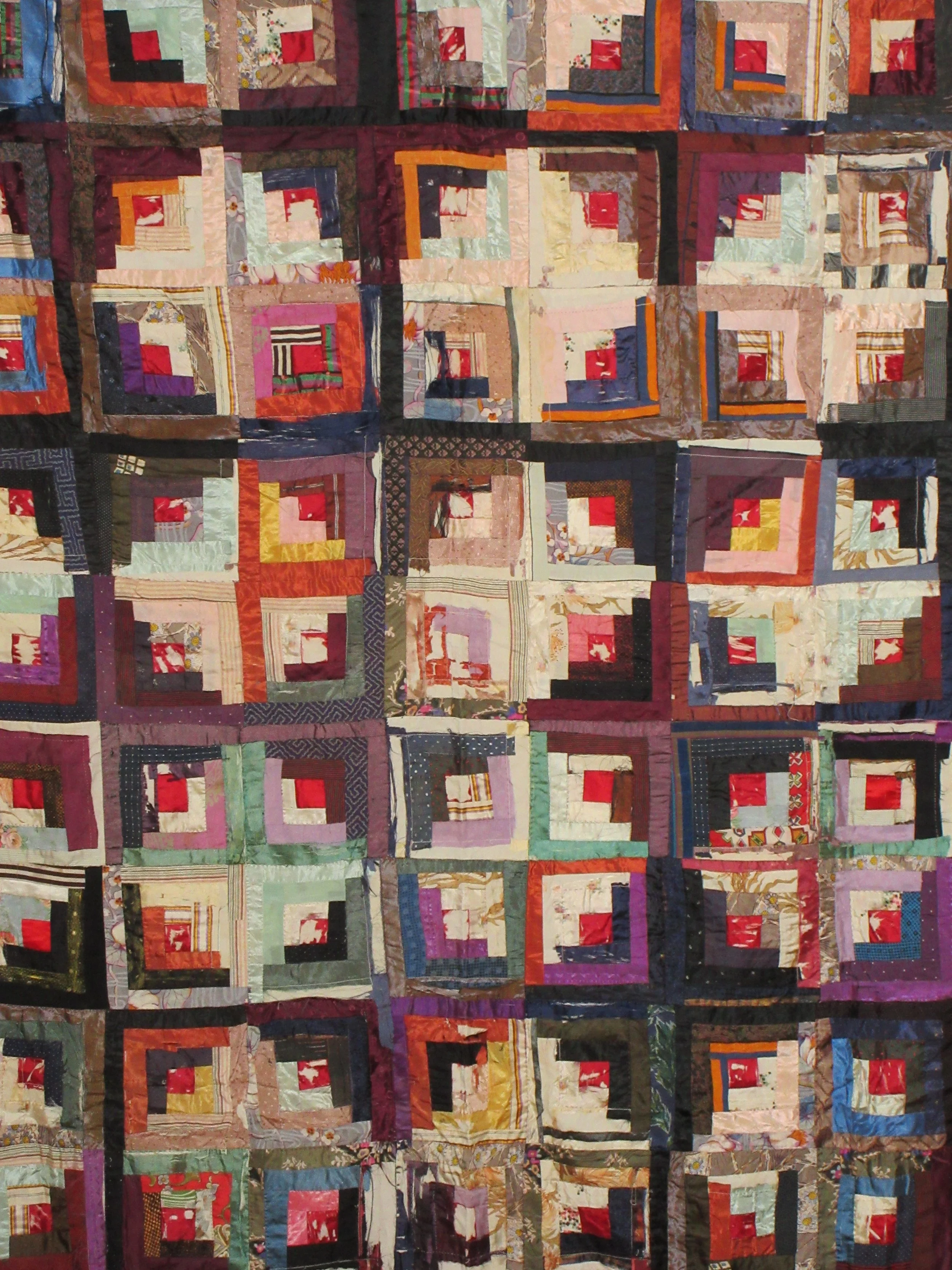 A colorful patchwork quilt made of various fabric squares arranged in a geometric pattern.