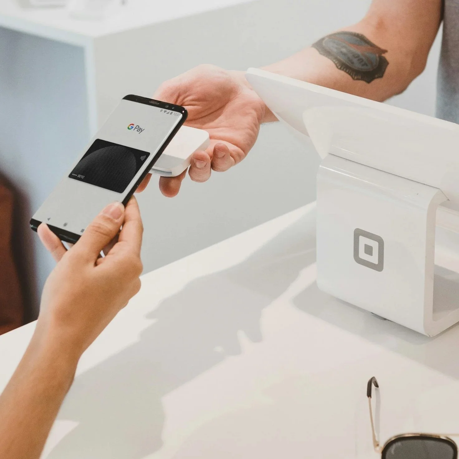 Person making a contactless payment with a smartphone at a point of sale terminal.